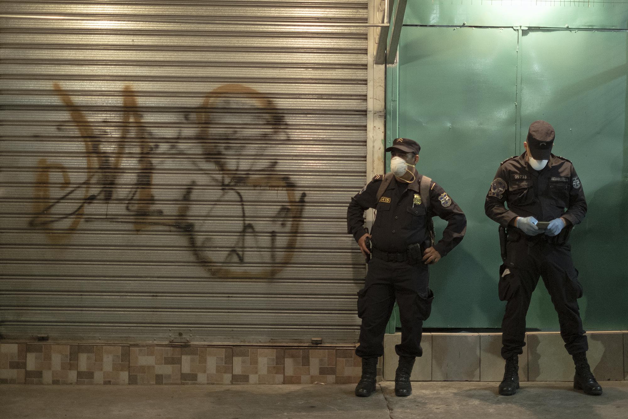 La Policía montó guardia en cada uno de los mercados del área metropolitana de San Salvador, entre ellos el mercado Sagrado Corazón, donde se desplegaron 200 agentes. en la imagen, junto a los policías, una pintada de la Mara Salvatrucha, que controla esa parte del Centro. Foto de El Faro: Carlos Barrera