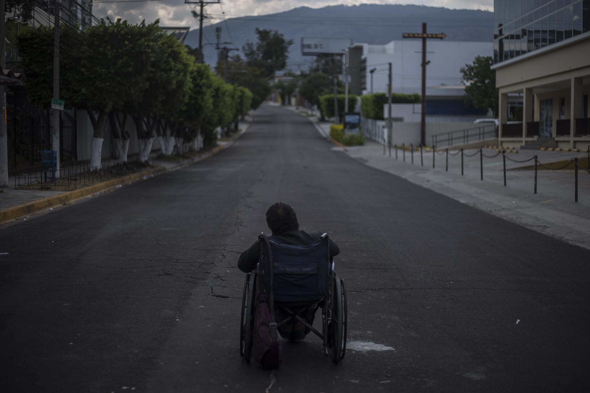 La tarde del sábado 21 de marzo, San Salvador vivió horas inusuales. Después que la mañana de ese día el presidente Nayib Bukele anunciara por tuit una cadena nacional para la noche, las calles de San Salvador quedaron vacías. Jorge Carballo, de 63 años, postrado en su silla de ruedas, esperaba una limosna sobre la calle La Mascota y la alameda Manuel Enrique Araujo. En media hora, consiguió que desde un vehículo le regalaran unas monedas. Foto de El Faro: Víctor Peña.
