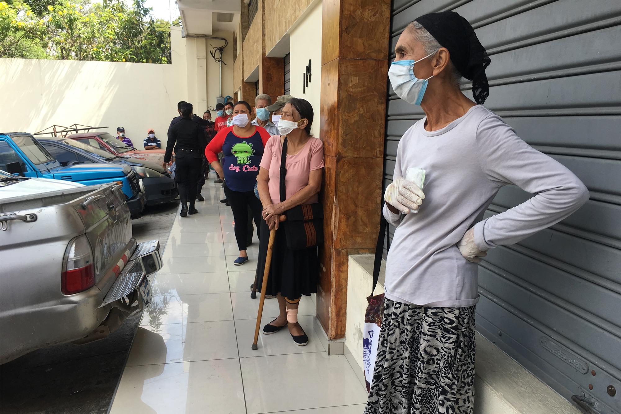 La fiscalización en la entrega del subsidio de $300 a familias vulnerables fue un punto medular en las discusiones del Comité. En la imagen, tomada el 28 de marzo, un grupo de mujeres intenta averiguar si son beneficiarias del subsidio. Foto de El Faro/Valeria Guzmán