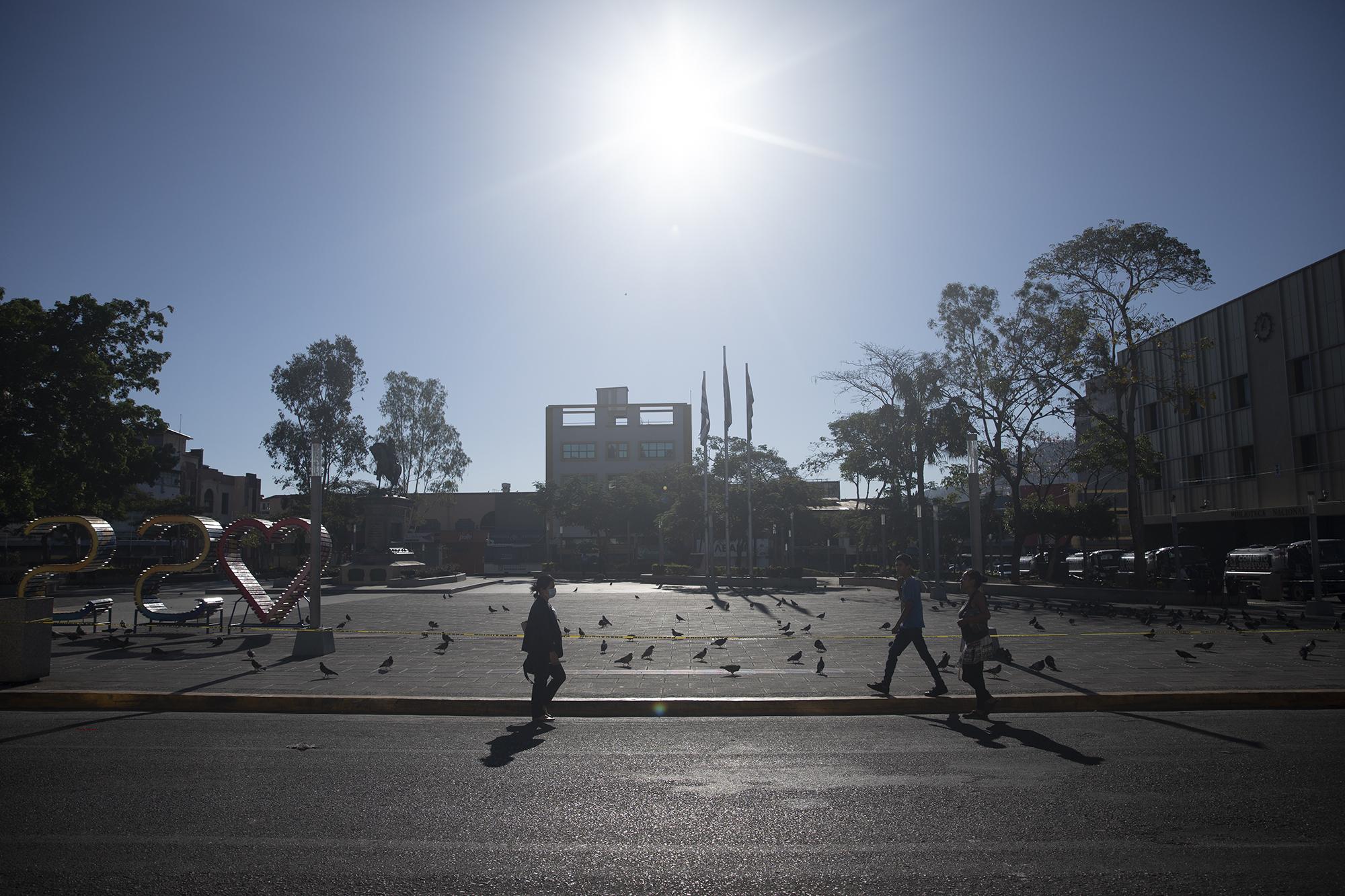 Solo algunas personas transitan por el Centro en este tiempo de cuarentena. Personas que vuelven de sus empleos, policías, militares, desamparados o vendedores informales que salen a la rebusca de algo para comer. Así lucía este domingo la plaza Gerardo Barrios, el punto cero de la capital. Foto de El Faro: Carlos Barrera