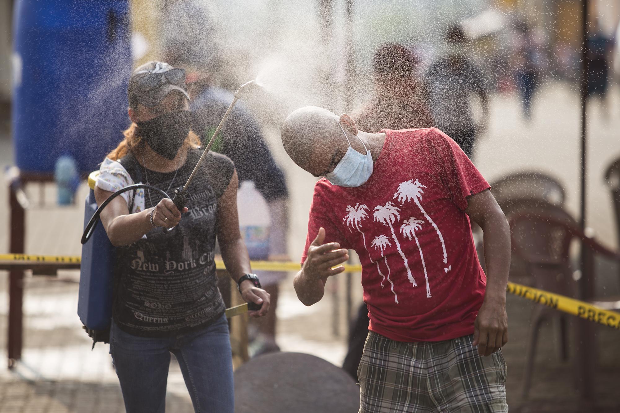 En las calles del municipio de Nahuizalco, en el departamento de Sonsonate, trabajadores de la Alcaldía desinfectaban a los pobladores. Los rociaban con germysol, un desinfectante que se mezcla con agua para eliminar bacterias.  Esta medida es implementada cerca del mercado y los agencias bancarias, lugares propensos a aglomeraciones.