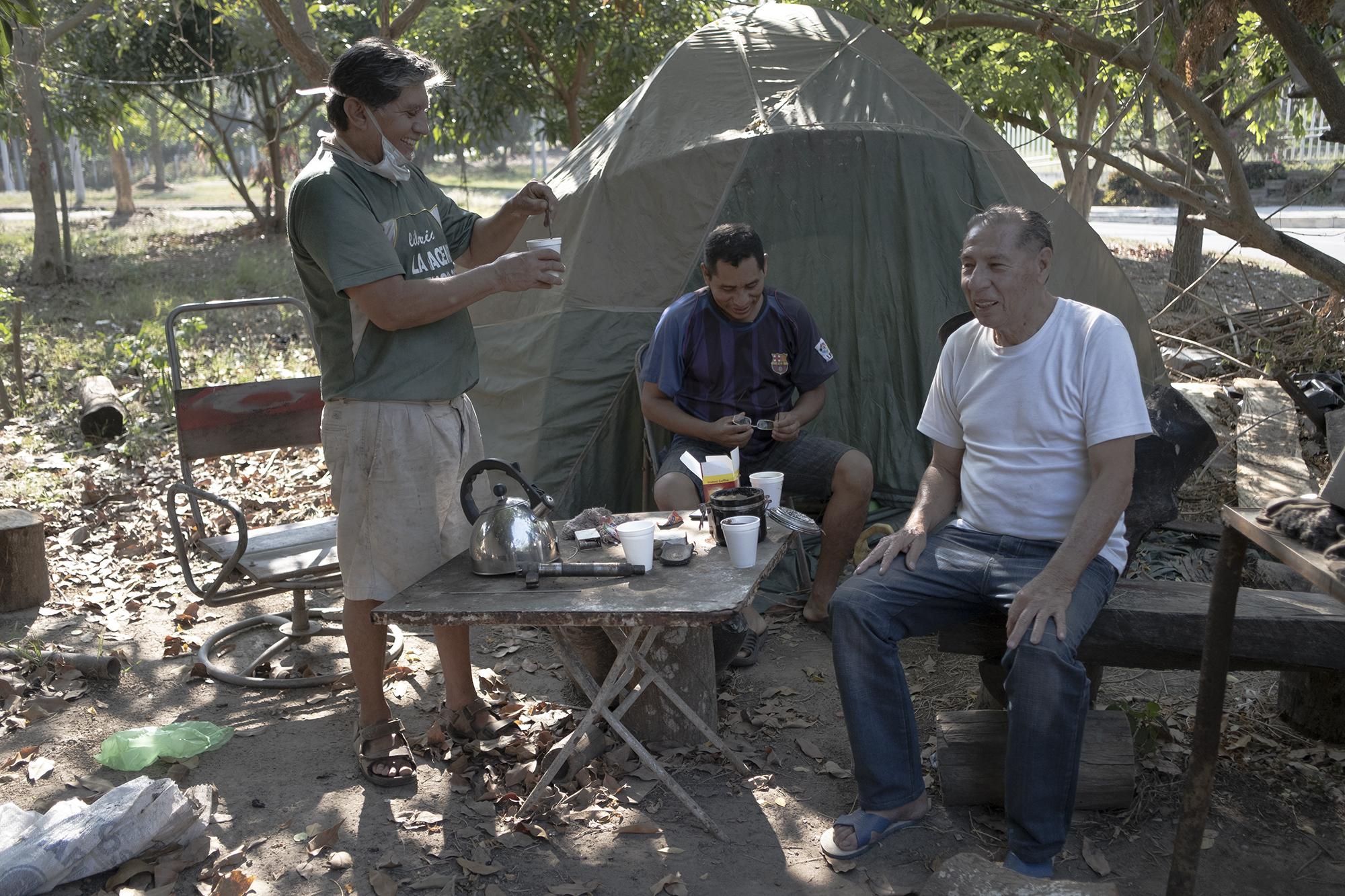 Jesús Urrutia (derecha) de 71 años de edad y Manuel Cabrera de 49, durante una visita a su amigo Luis Flores, los tres son vecinos, las casas no tiene divisiones, es suficiente con dar unos pasos y estar en la casa de otra persona, ellos dijeron que mantienen la distancia y evitan saludarse con el apretón de manos. Todos los días se reúnen a las 3:30 para tomar café, Jesús además de ser amigo de Luis Flores también es su único cliente en el pequeño taller improvisado.