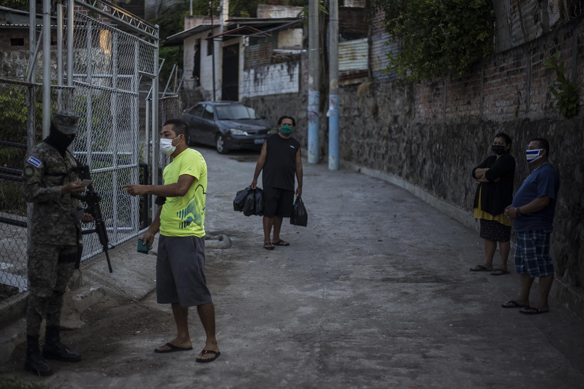 With his documentation in hand, the local resident in neon yellow tried to leave his neighborhood to purchase goods at the pier. The emergency measures approved by the Legislative Assembly permit free circulation for families to stock up on goods. In La Libertad, though, armed forces ignored the law on Saturday, refusing to let people out of their homes. One woman reported that she left her truck full of bananas, which she had planned to take to market in San Salvador, parked at her house. Soldiers had refused to let her leave, despite provisions allowing vendors of essential goods to travel to market. In another instance, the soldiers changed their mind when a man yelled out: “Hey, baker! Hurry up with that bread!” The baker, who had stumbled upon this same checkpoint, was then allowed to move along to the marketplace.