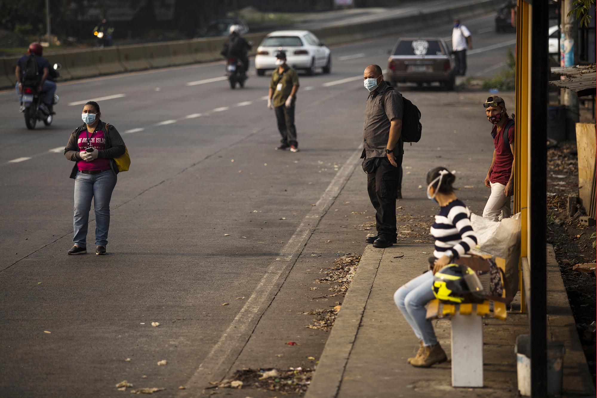 El jueves 7 de mayo, usuarios del transporte público esperaban en El Poliedro, en el municipio de Colón, la parada de autobuses que, todas las mañanas aglomera a cientos trabajadores que viajan a San Salvador. Foto de El Faro: Víctor Peña. 