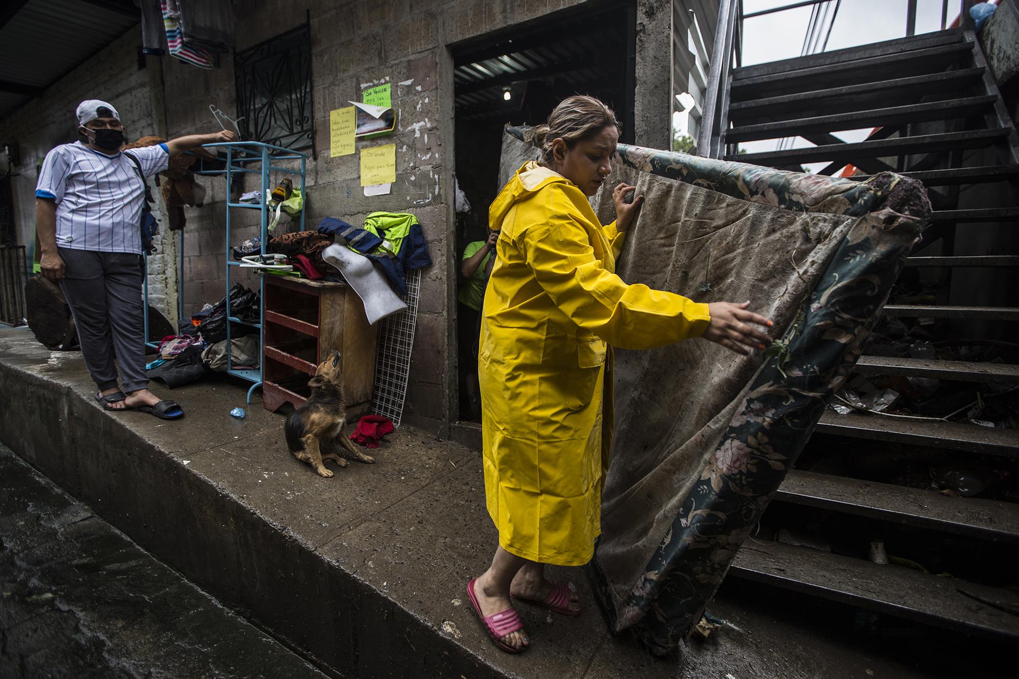 Marina despertó por el ruido del agua. La corriente de la quebrada golpeaba las paredes de lámina de su vivienda. Corrió, tomó a sus dos hijos y subieron hasta el pasaje principal de la comunidad Nuevo Israel. En la imagen, Marina Cordero, recoge una parte de su cama, después de que la tormenta tropical Amanda destruyó por completo su casa y arrastró a su perro. 