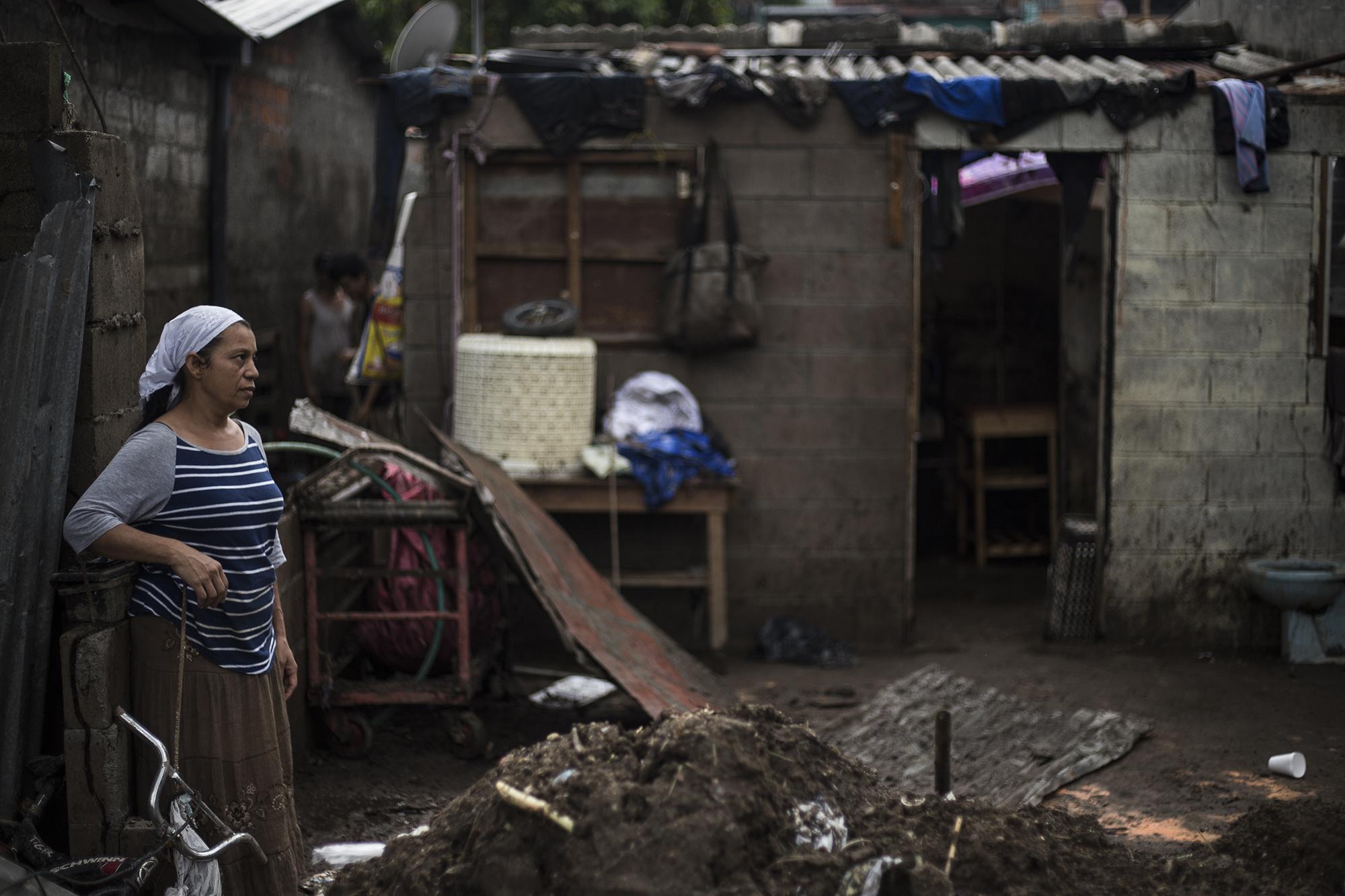 El cauce del río Acelhuate destrozó las bordas y subió hasta el techo de las viviendas. Rosa Miriam Sánchez observa lo poco que quedó de su hogar, ubicado en la ribera del río que sirve como conducto de las aguas negras de la capital. Foto de El Faro: Víctor Peña. 