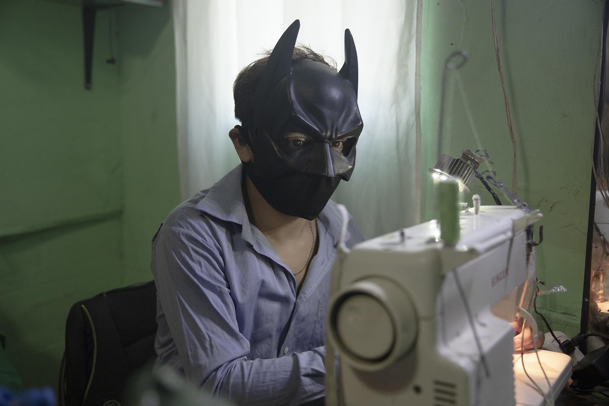 Stanley trabaja en la elaboración de mascarillas para venderlas y poder obtener dinero. El taller lo tiene en su habitación, la labor la realiza desde que inició la cuarentena y no pudo seguir animando fiestas. Foto de El Faro: Carlos Barrera