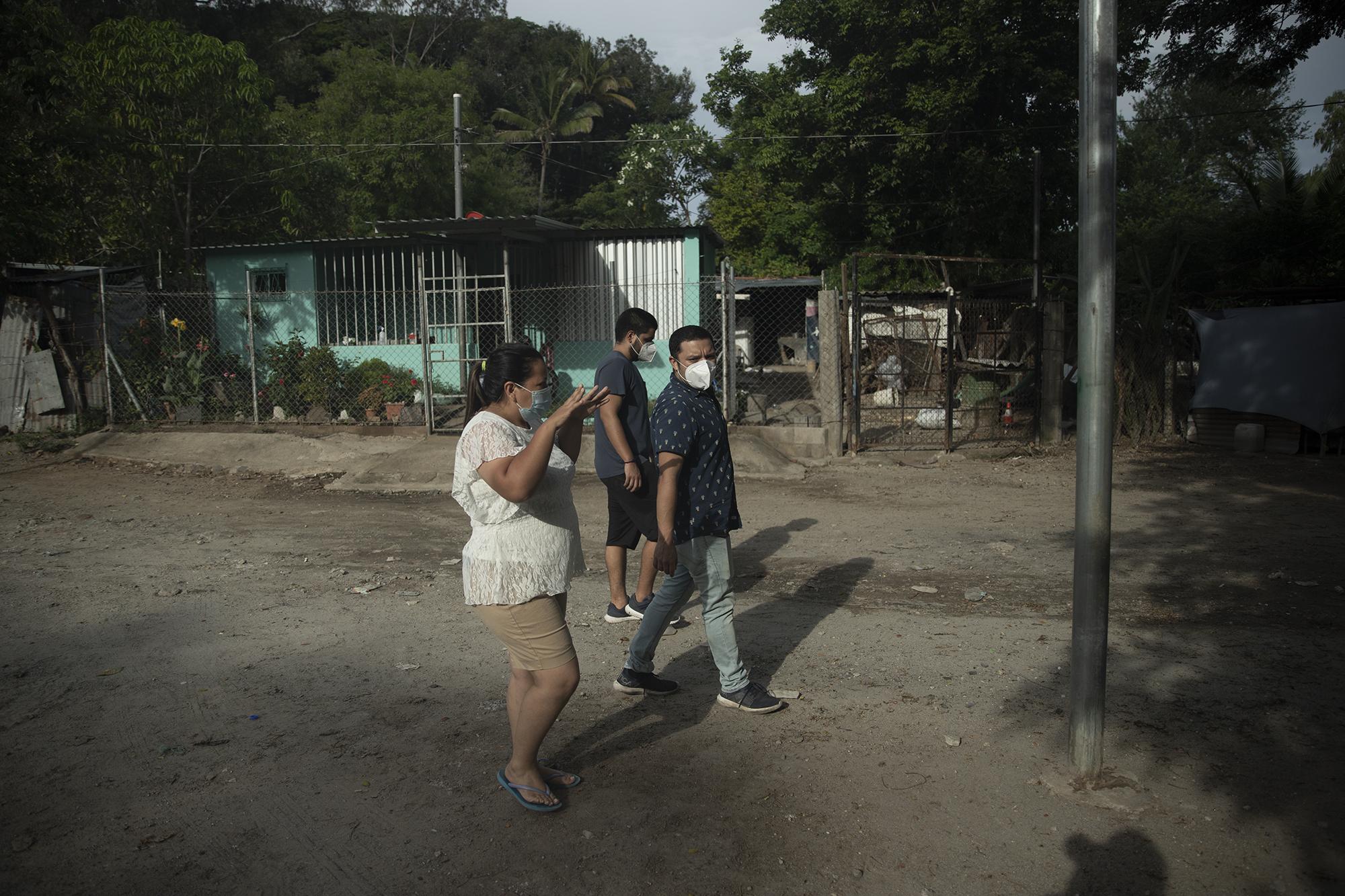 Maribel López camina junto a Dino Safie y Héctor Silva en las calles de Changallo, Ilopango. Maribel es trabajadora social de la alcaldía de Ilopango y coordina ayuda para las familias damnificadas de Changallo. Foto de El Faro: Carlos Barrera.