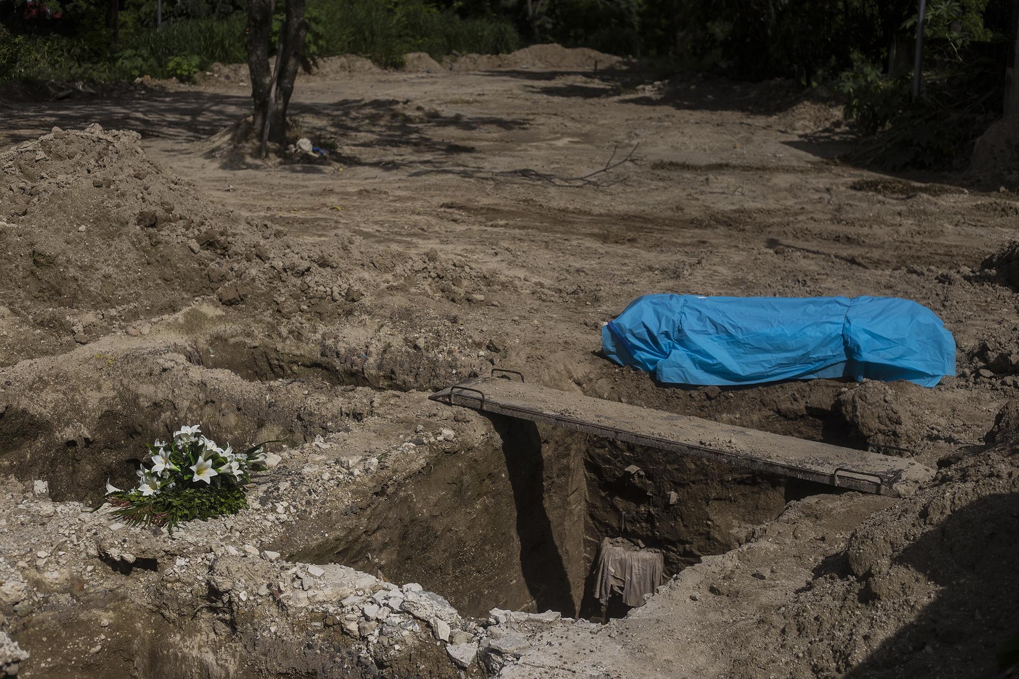 A body awaits its burial under covid-19 protocols in the La Bermeja cemetery in San Salvador. The Ministry of Health has reported a total of 600 burials of suspected or confirmed covid-19 victims since June 19. The hospital network has collapsed, according to patients and medical staff, and some cemeteries in the Metropolitan Area of San Salvador, like Ilopango, are full.