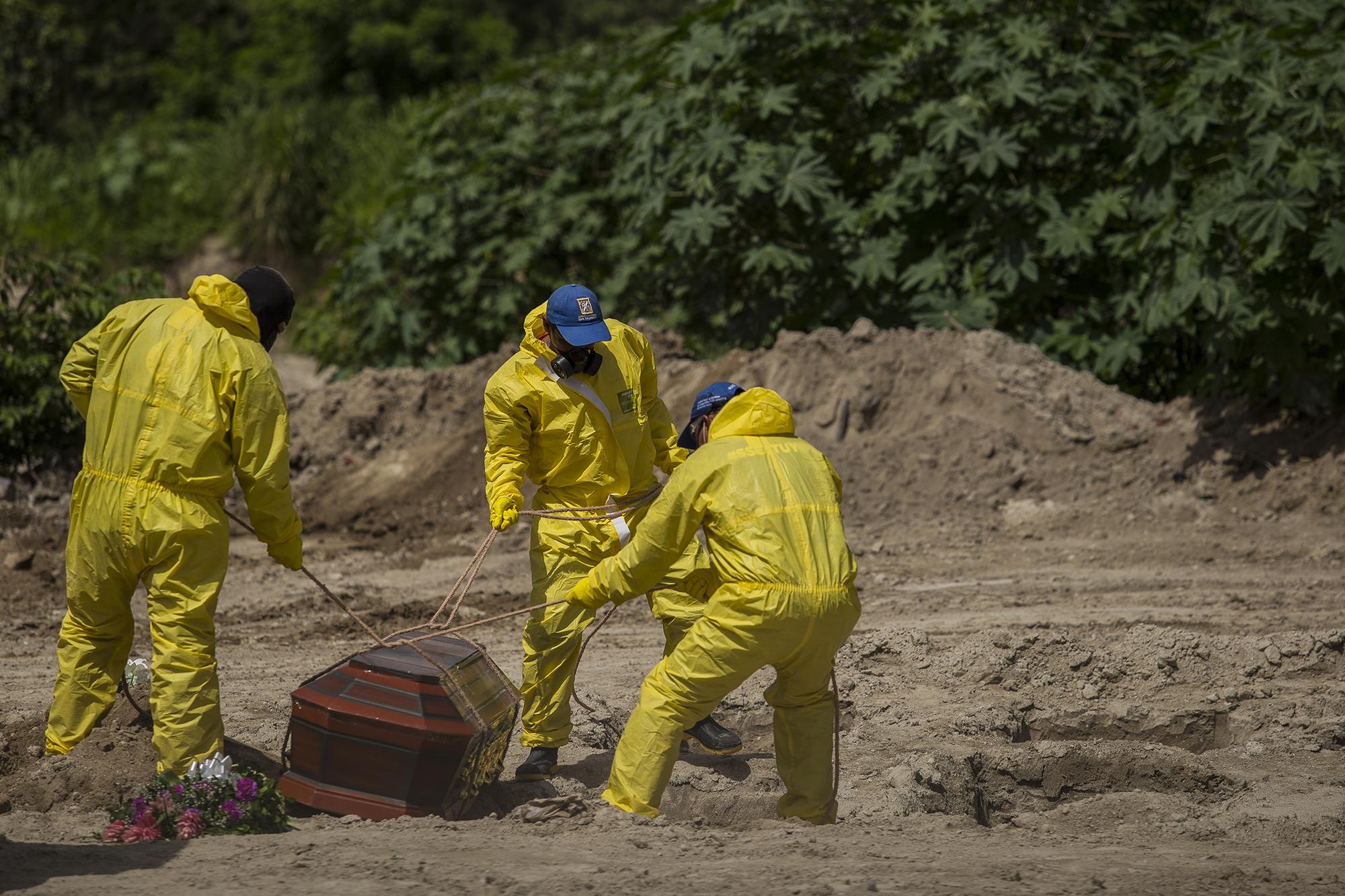 Inhumación en el cementerio general La Bermeja, en San Salvado, el 23 de junio de 2020. Solo en este lugar, las autoridades registran un promedio de hasta 15 entierros por día con el protocolo covid-19. Según Salud, la cifra alcanzó hasta junio promedios de 25 inhumaciones diarias. Foto de El Faro: Víctor Peña. 