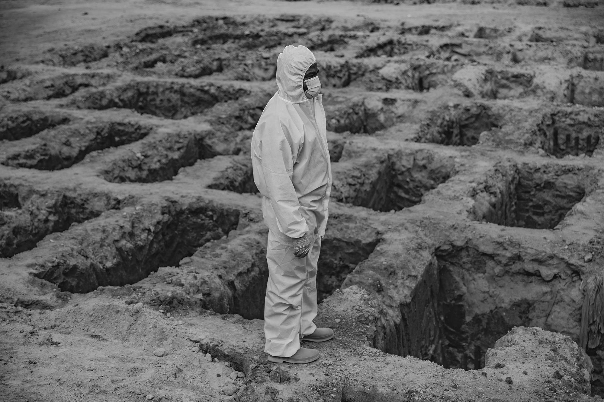 Santos Leiva espera, al borde de las fosas del cementerio La Bermeja, en San Salvador, su turno para entregar el ataúd con el cuerpo de la persona que murió por la covid-19. Para el funerario, este es uno de los momentos más sofocantes: 