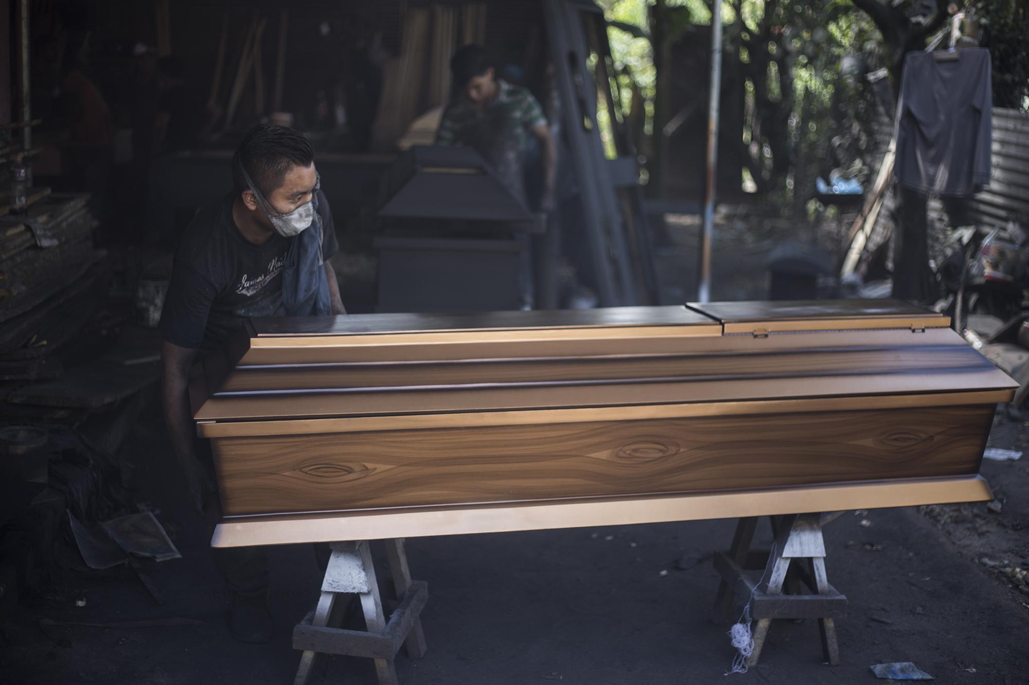 Este es un ataúd económico. Un estilo que se fabrica en este taller cada vez que una funeraria lo encarga. “La Batellita”, como le llaman los carpinteros, se comenzó a ensamblar la mañana del 3 de agosto, y una familia del cantón Apulo, en el municipio de Ilopango, lo compró el 12 de agosto para el funeral de una mujer que murió en el hospital La Divina Providencia, de San Salvador. A lo largo de su construcción, este féretro recorre varias manos, varias vidas y distintas historias.