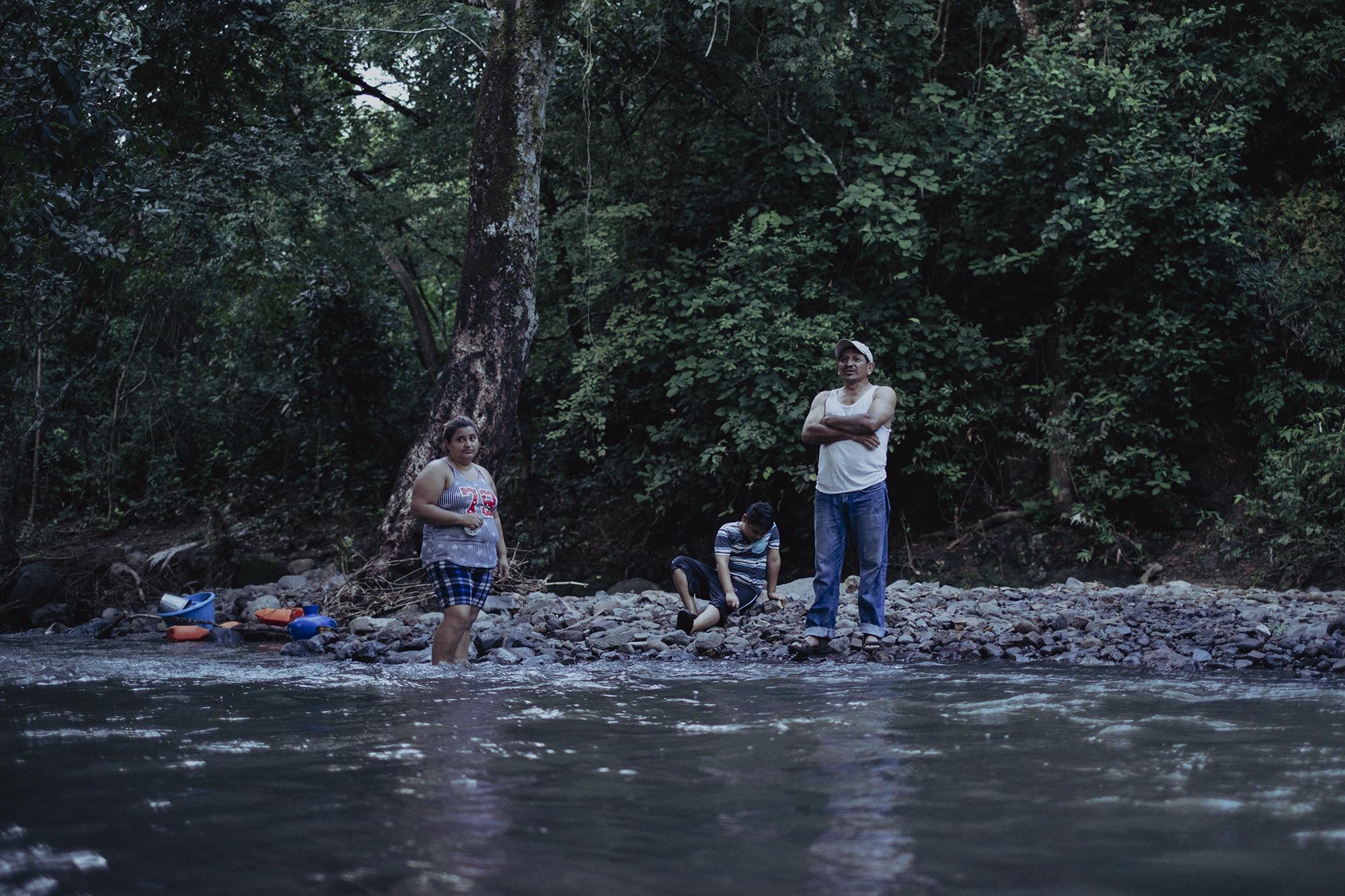 Fidencio Cartagena de 50 años, María Portillo, de 36, y Josué Cartagena, de 9, son una familia salvadoreña que vive en el caserío Sazalapa en Honduras. María lamenta que los militares han impedido que su madre ingrese a El Salvador en este paso para atender a una intervención médica. Foto de El Faro: Carlos Barrera.