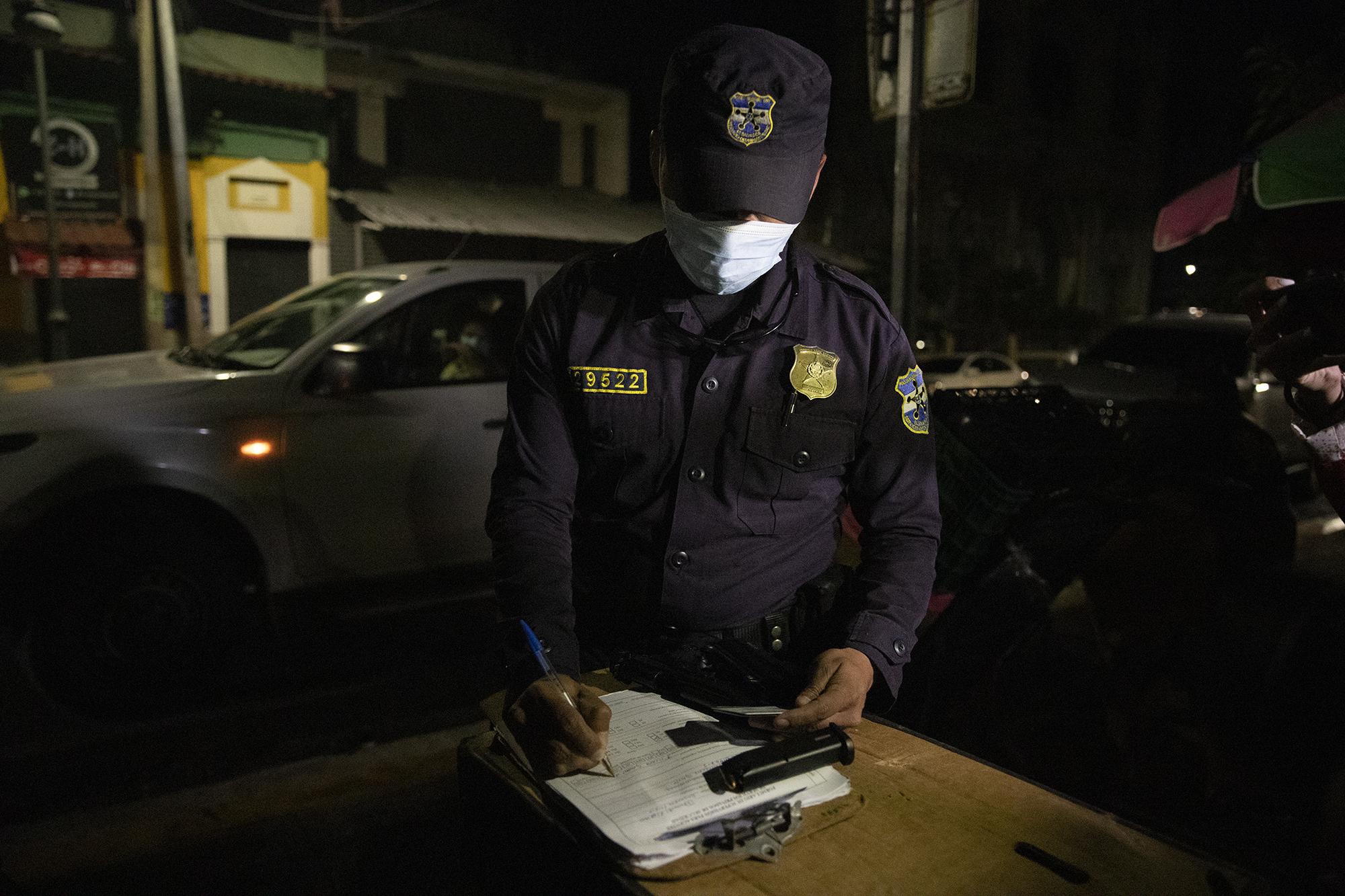 Agentes de la Policía Nacional Civil revisaron los permisos de armas de los fiscales que efectuaron un allanamiento en las instalaciones del Ministerio de Salud en 2020, cuando buscaban pruebas de la corrupción en compras relacionadas con la pandemia. Foto de El Faro: Carlos Barrera