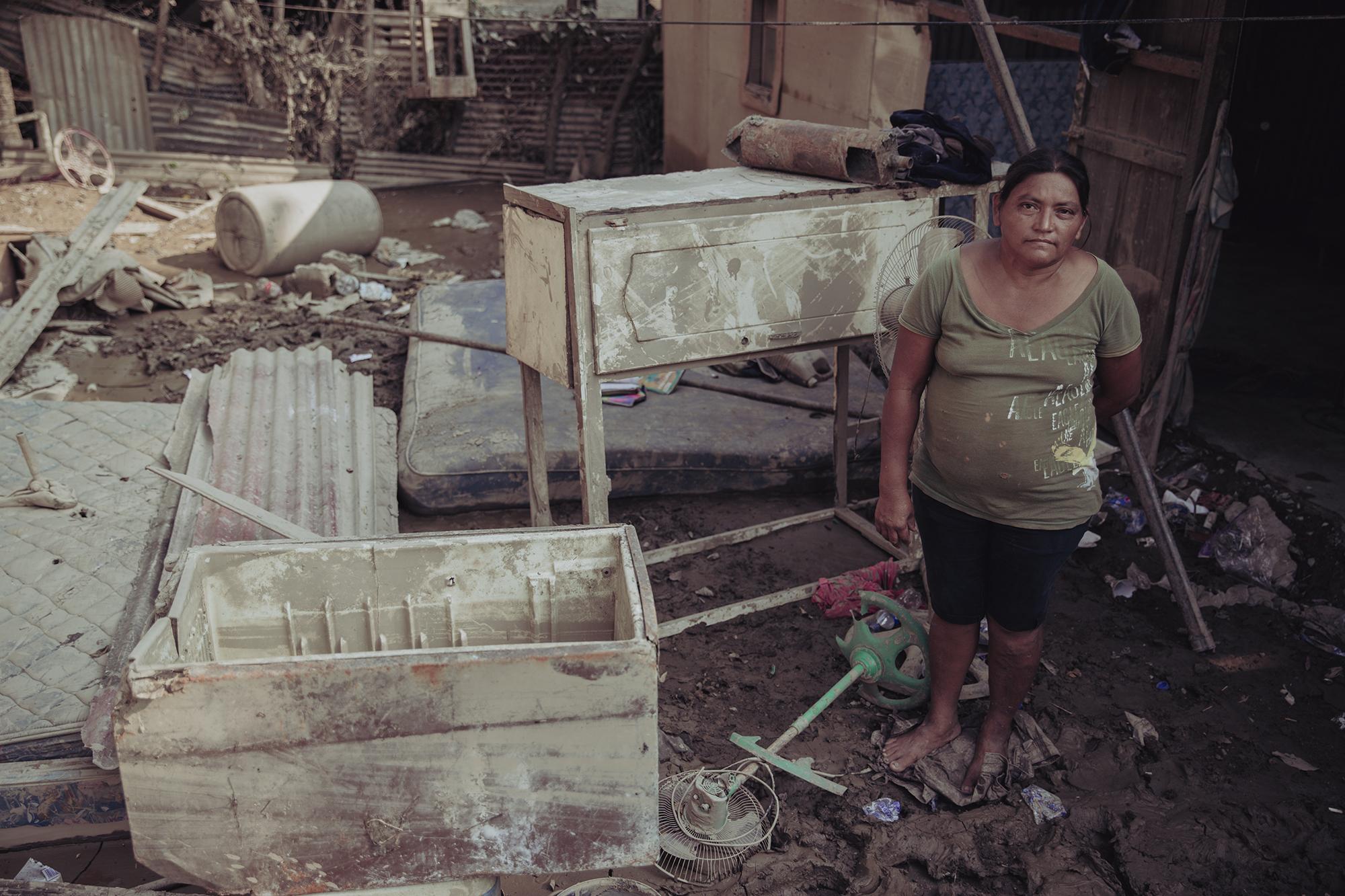 María Orellana stands in what remains of her sister’s house in Colonia Canaan of La Lima, in the department of Cortés, Honduras. Eta caused a nearby creek to overflow, flooding the community and stripping the families of all their possessions. Photo: Carlos Barrera/El Faro