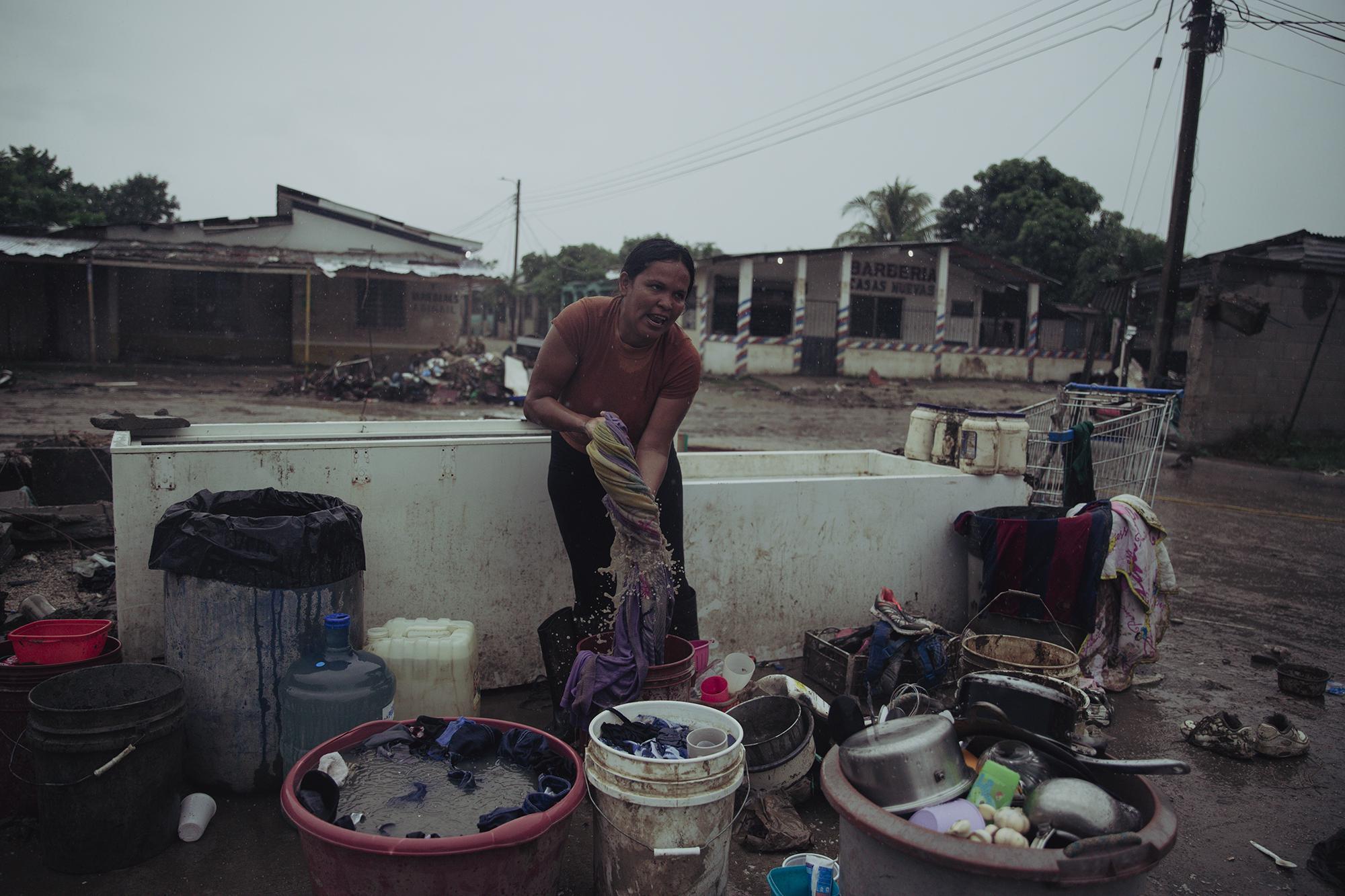 Alicia Suazo es residente del barrio Rivera Hernández de San Pedro Sula, Honduras. Durante las primeras horas en las que el huracán Iota golpeó el país, la mujer de 35 años se dedicó a recolectar todo lo que la corriente arrastró hasta su sector de residencia. El lugar estaba abandonado a causa de los estragos de Eta, y los que han permanecido corrían el riesgo de quedar incomunicados y aislados con la llegada de Iota. Foto de El Faro: Carlos Barrera.