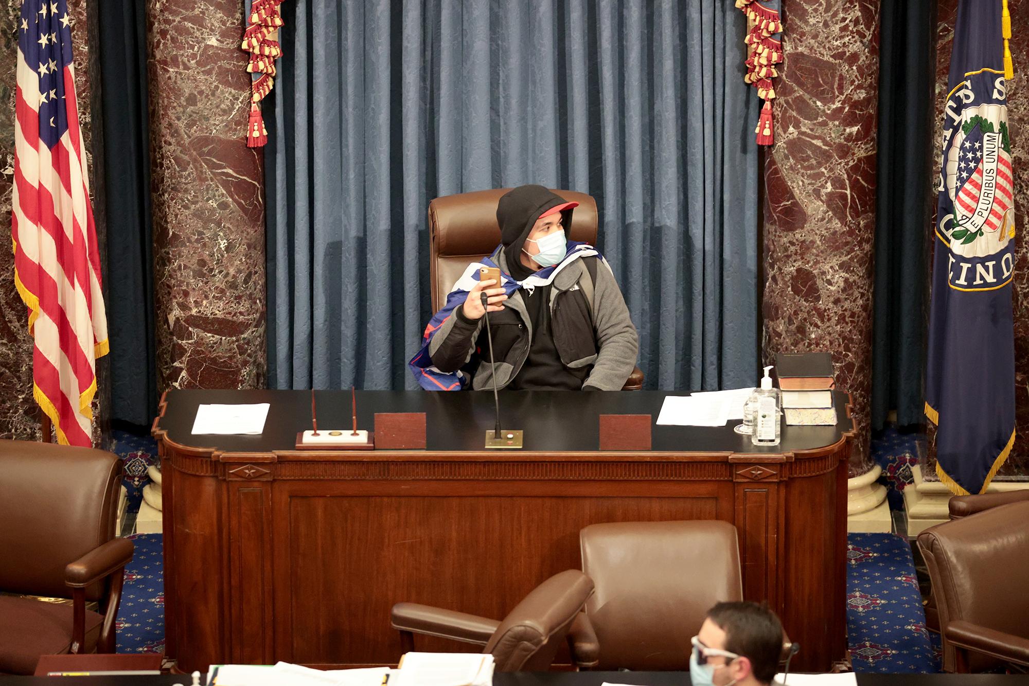 Uno de los manifestantes usurpó la silla en la Cámara del Senado. El Congreso celebró una sesión conjunta hoy para ratificar la victoria del Colegio Electoral 306-232 del presidente electo Joe Biden sobre el presidente Donald Trump. Los manifestantes pro-Trump han ingresado al edificio del Capitolio de Estados Unidos después de manifestaciones masivas en la capital de la nación. Foto de El Faro: Win McNamee / Getty Images / AFP.