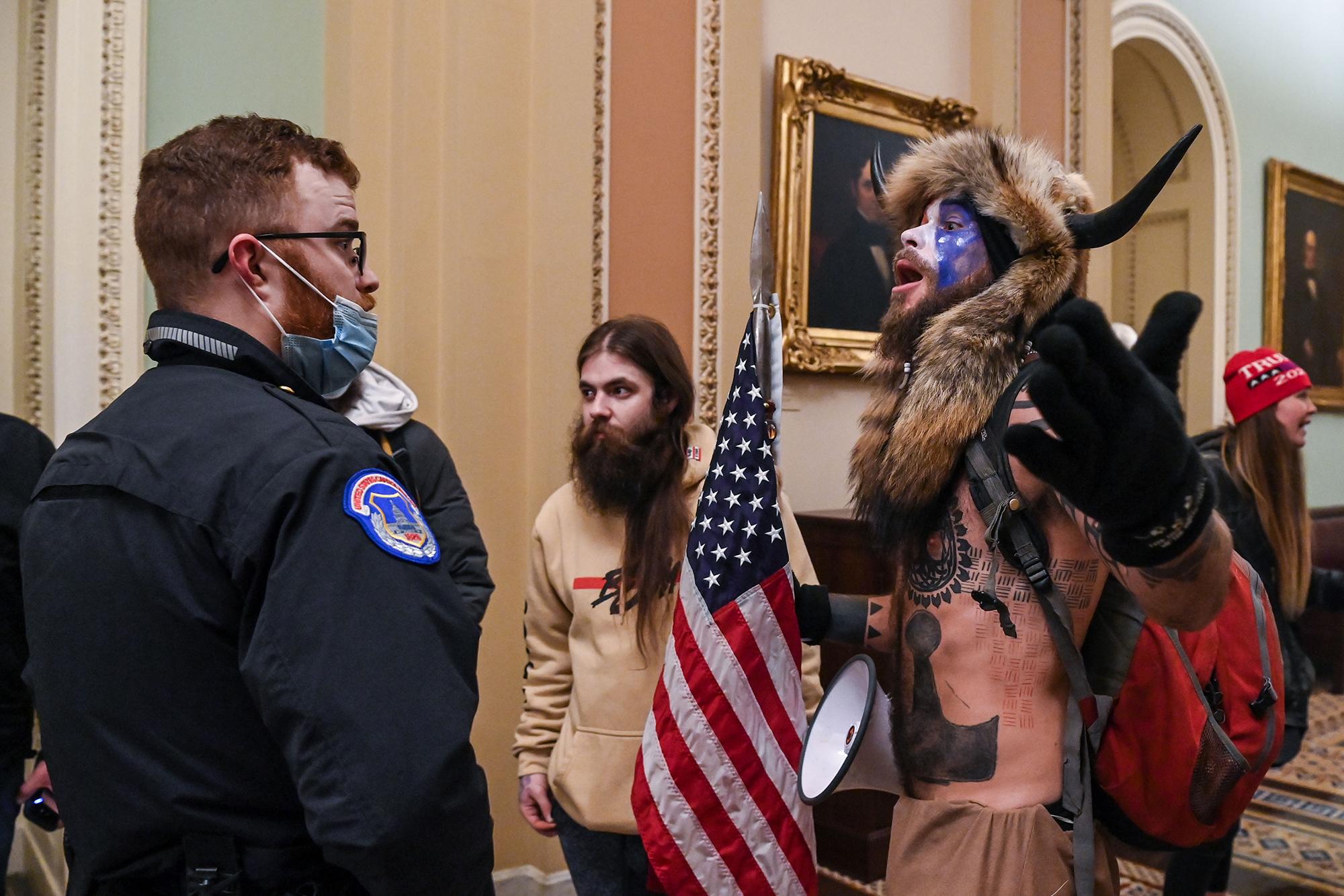 Los agentes de policía del Capitolio de los Estados Unidos intentan impedir que los partidarios del presidente de los Estados Unidos, Donald Trump, incluido Jake Angeli (derecha), un partidario de QAnon conocido por su rostro pintado y su sombrero con cuernos, ingresen al Capitolio el 6 de enero de 2021 en Washington, DC. - Los manifestantes violaron la seguridad y entraron al Capitolio mientras el Congreso debatía la Certificación de Voto Electoral para las elecciones presidenciales de 2020. Foto de El Faro: Saul LOEB / AFP.