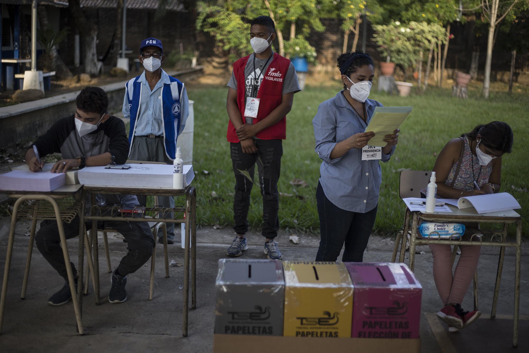 Miembros de una JRV en San Salvador esperan la llegada de votantes, el 28 de febrero de 2021. Foto: Víctor Peña / El Faro