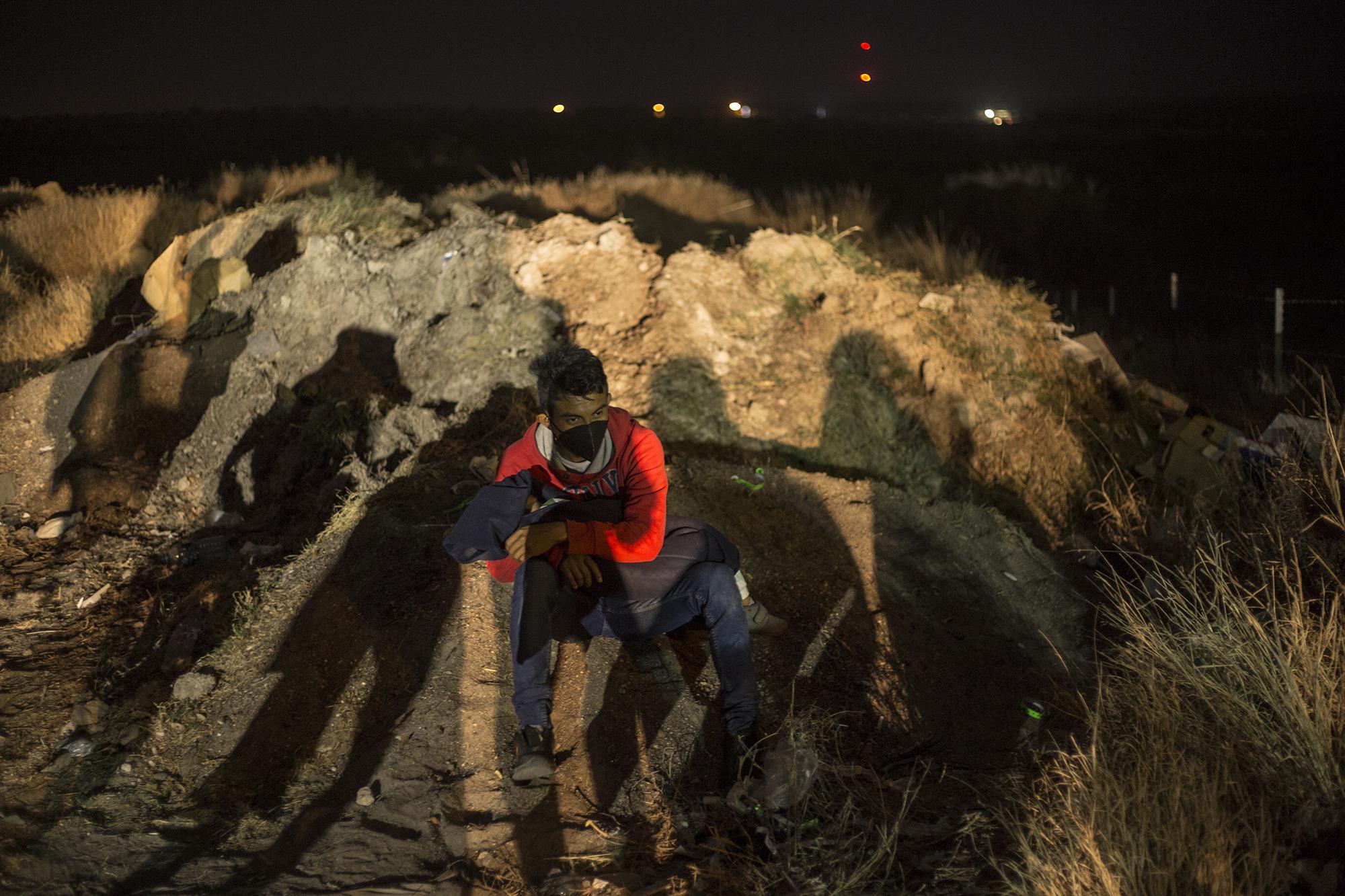 Un hombre espera bajo la sombra de otros migrantes con su hijo entre los brazos. Descansa mientras sus familiares se registran con las autoridades. Es parte de una familia entera que salió un mes atrás del departamento de San Marcos, en Guatemala.