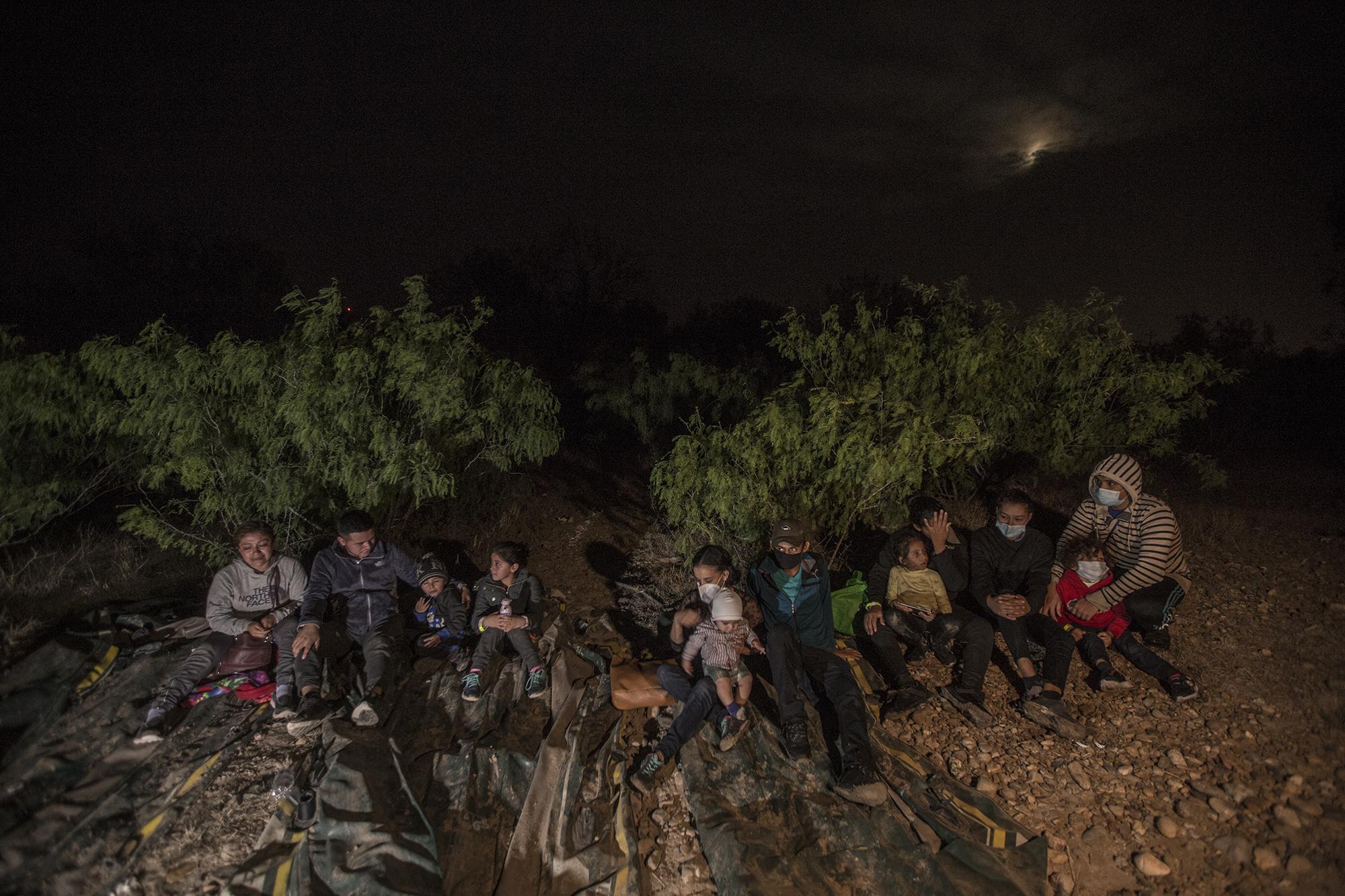 En la imagen hay tres familias que cruzaron juntas el río. A la izquierda, Beili Cinto y Ubilder Navarro, ambos de 25 años. Huyeron con sus dos hijos el 15 de enero de la aldea Champollap, en el departamento de San Marcos, Guatemala. Ubilder tuvo problemas con sus hermanos por la herencia de un terreno. Le quemaron su casa y los amenazaron de muerte. En medio hay una pareja: Fátima Pacheco, de 29 años y José Francisco, de 22. Huyen del departamento de Olancho, en Honduras. Viajaron sin coyote y con Diego, su hijo de cinco meses. A la derecha, Enna Turcios llora sin cesar. La acompaña su hija. Junto a ella hay una pareja: Jenny Menjívar, de 21 años, y Marlon Córdova, quienes también viajan con un menor. Juntos salieron el 1 de febrero del municipio de Marcovia, en el departamento de Choluteca, Honduras. El grupo de migrantes entró a Estados Unidos, pero las autoridades fronterizas las devolvieron días atrás y las devolvieron a Ciudad Juárez, México, a cientos de kilómetros de este punto por donde volvieron a cruzar el Bravo. El grupo fue secuestrado durante 15 días por un grupo del crimen organizado de México que extorsionó a sus familias. Cuando cobraron, los mismos delincuentes los llevaron a la orilla del río para entrar de nuevo a Estados Unidos. “Ya no queremos regresar a esa pesadilla. Esto es lo peor que nos ha pasado en la vida”, dice Enna.