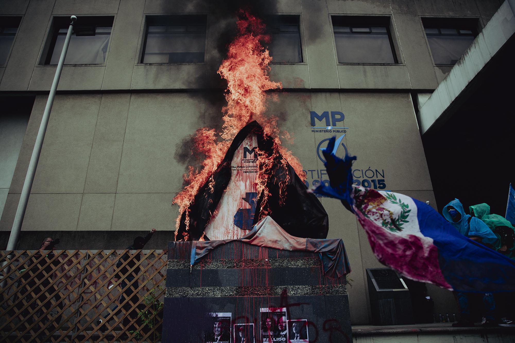 A group of protestors briefly set fire to the insignia of the Public Prosecutor