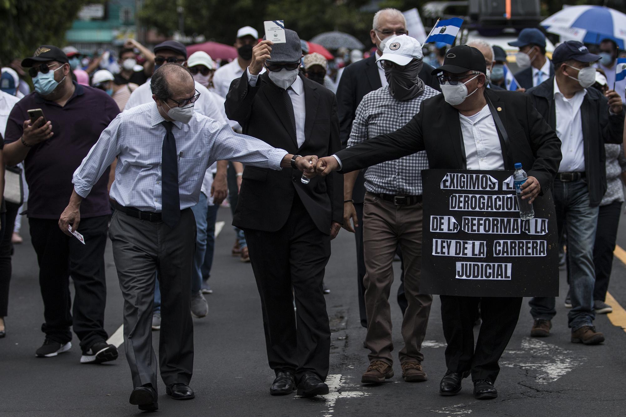 El juez de Sentencia de San Miguel y exmagistrado de la Sala de lo Constitucional, Sidney Blanco, saluda a otro asistente a la marcha de los jueces, que el 7 de septiembre protestaron contra la purga del 30 % de los juzgadores en función ordenado por la Asamblea Legislativa controlada por Bukele. Foto de El Faro: Víctor Peña.