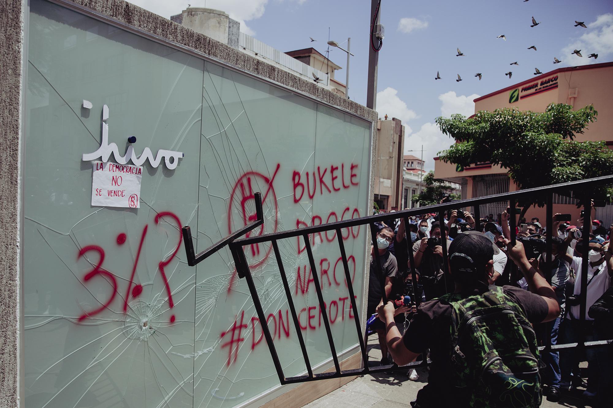 Un reducido grupo de manifestantes intentaba destruir la cabina del cajero de bitcoin ubicado en la Plaza Gerardo Barrios, lo hacían con poco apoyo y alentados por un reducido grupo de personas que los rodeaban. El resto eran curiosos y periodistas que intentaban tener la mejor toma de dicha acción.