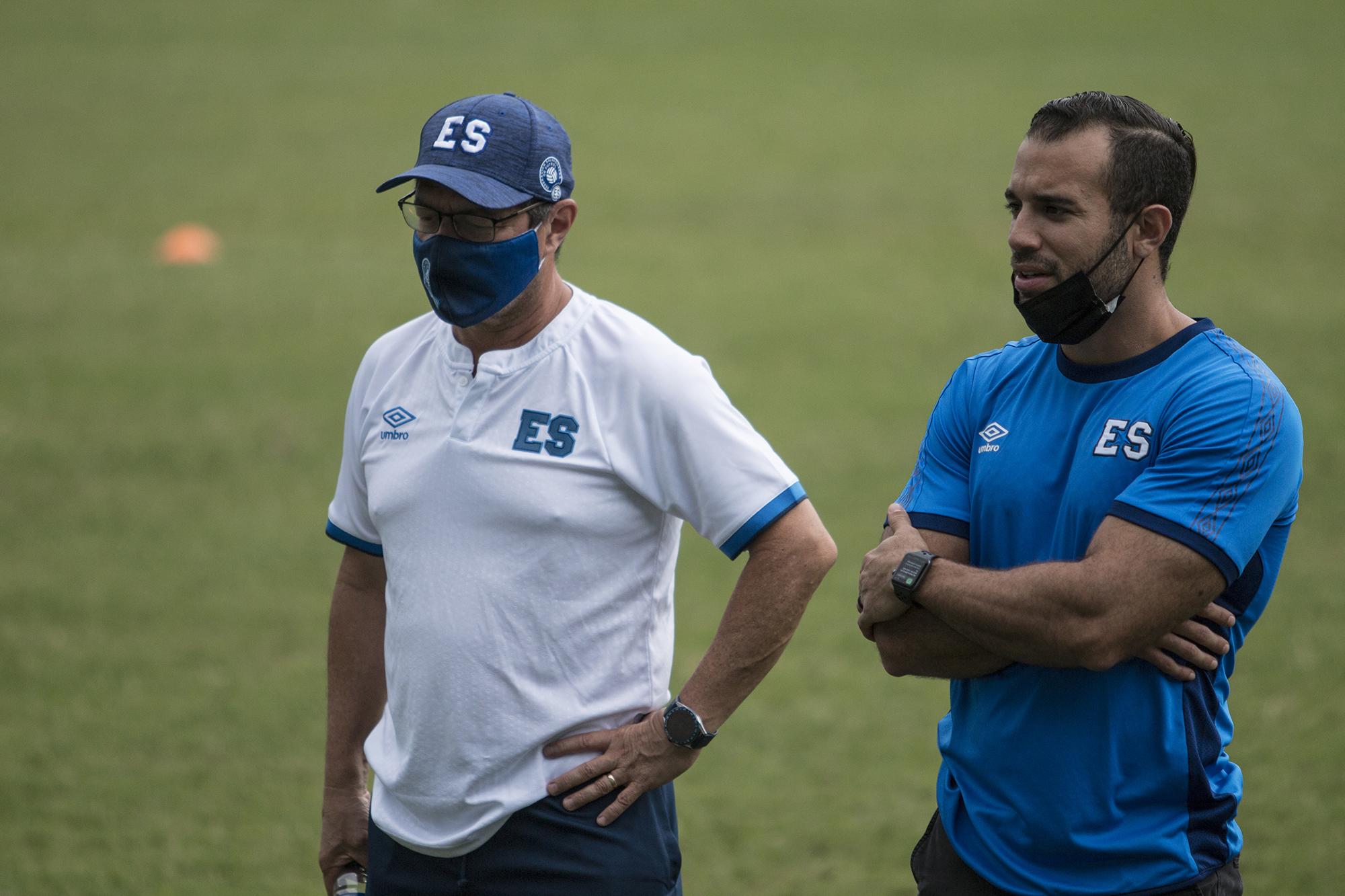 El entrenador Hugo Pérez (izquierda) observa un entreno al lado de Diego Henríquez, director deportivo de la Federación Salvadoreña de Fútbol. Henríquez es el responsable del reclutamiento de varios jóvenes nacidos fuera del país para integrarlos a la selección. Foto de El Faro/ Víctor Peña.