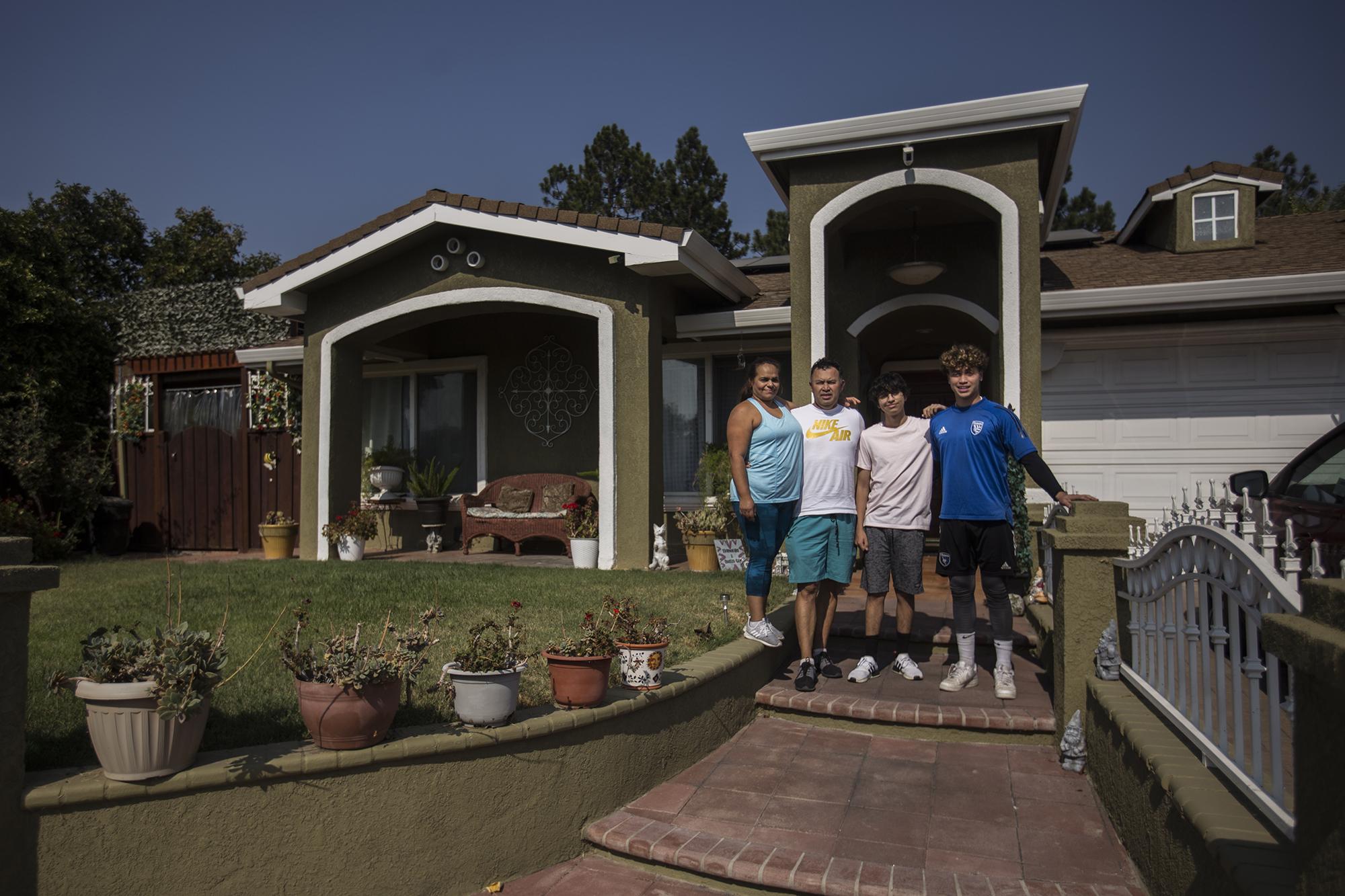 La familia Alguera Mercado posa frente a su casa en San José, California. Edgar Alguera llegó a Estados Unidos documentado en 1994, pero él y su esposa se beneficiaron del Estatus de Protección Temporal (TPS) después del terremoto del 13 de enero de 2001. Futbolista en El Salvador, ahora tiene una empresa contratista en la rama de la construcción. Edgar es el entrenador personal de Damián, a la derecha con camiseta azul, que con solo 17 años trata de hacerse un puesto como guardameta en la selección de fútbol de El Salvador.