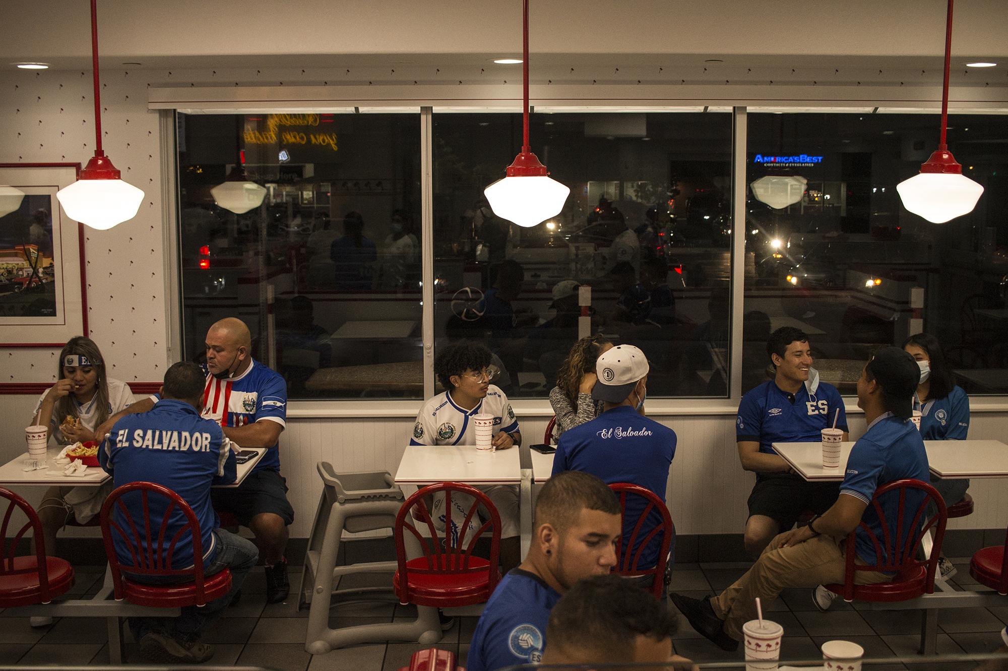 Aficionados se reúnen en una sucursal de hamburguesas In and Out, en Carson, California, cerca del estadio donde la Selecta acaba de terminar su juego contra Costa Rica. Es el único negocio abierto a las 12:30 de la madrugada y los salvadoreños lo abarrotan como unas horas antes abarrotaron el escenario deportivo donde jugó su equipo.