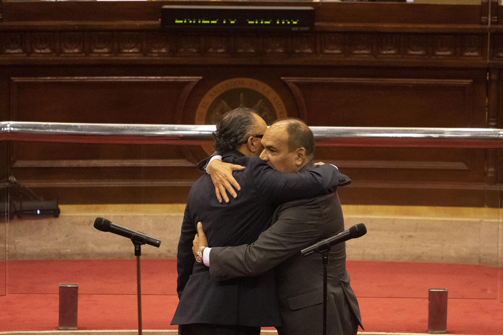El presidente de la Asamblea Legislativa, Ernesto Castro, se abraza con Óscar López Jeréz después de que este fue juramentado como presidente de la Corte Suprema de Justicia el 29 de junio del 2021, violando las normas establecidas en la Constitución. Con ese nombramiento, Bukele se hizo del control de los tres poderes del Estado. Foto de El Faro: Carlos Barrera