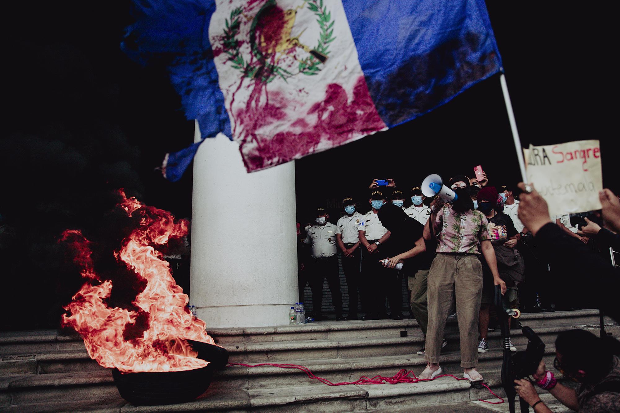 Al finalizar la protesta en Ciudad de Guatemala, algunas las personas quemaron llantas frente al Congreso. Fue una jornada que duró de las 6 de la mañana a las 4 de la tarde del 29 de julio del 2021 en la Ciudad de Guatemala y en diversas zonas del interior del país. Los manifestantes protestaron por la cooptación de las instituciones de justicia que en Guatemala ocurrió durante 2021, y cuyo símbolo fue la expulsión de la Comisión Internacional Contra la Impunidad en Guatemala, la destitución de fiscales que perseguían delitos de cuello blanco y el nombramiento de la fiscal Consuelo Porras, que ha hecho varios esfuerzos por desmontar casos judiciales de corrupción. Foto de El Faro: Carlos Barrera.