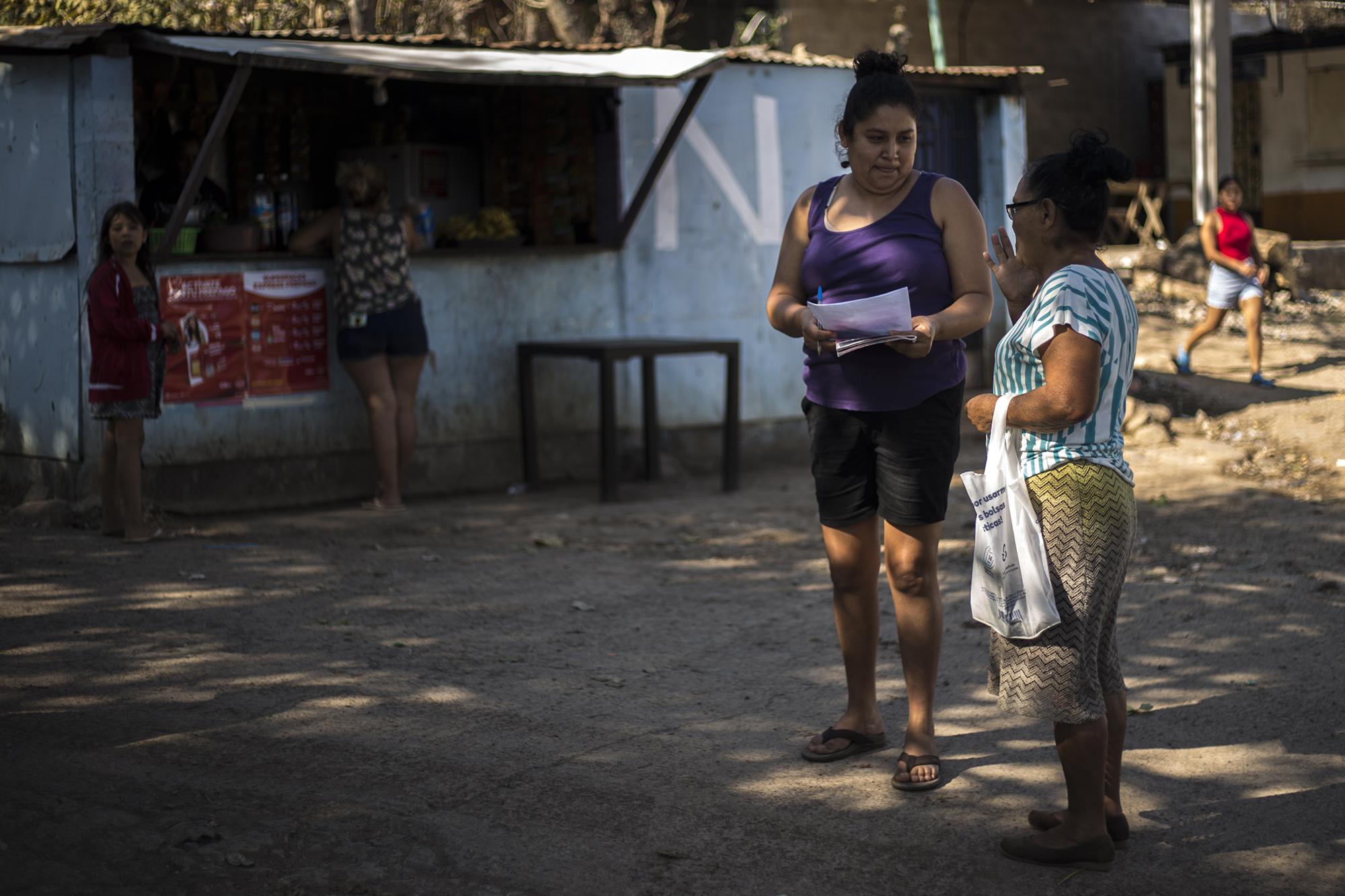 Erika vende números para la rifa de una bicicleta, la mañana del domingo 16 de enero de 2022, en la hacienda La Labor. La comunidad realiza estas actividades para recolectar dinero con el que pagan los gastos de abogados y alimentos para las personas detenidas. Foto de El Faro: Victor Peña. 