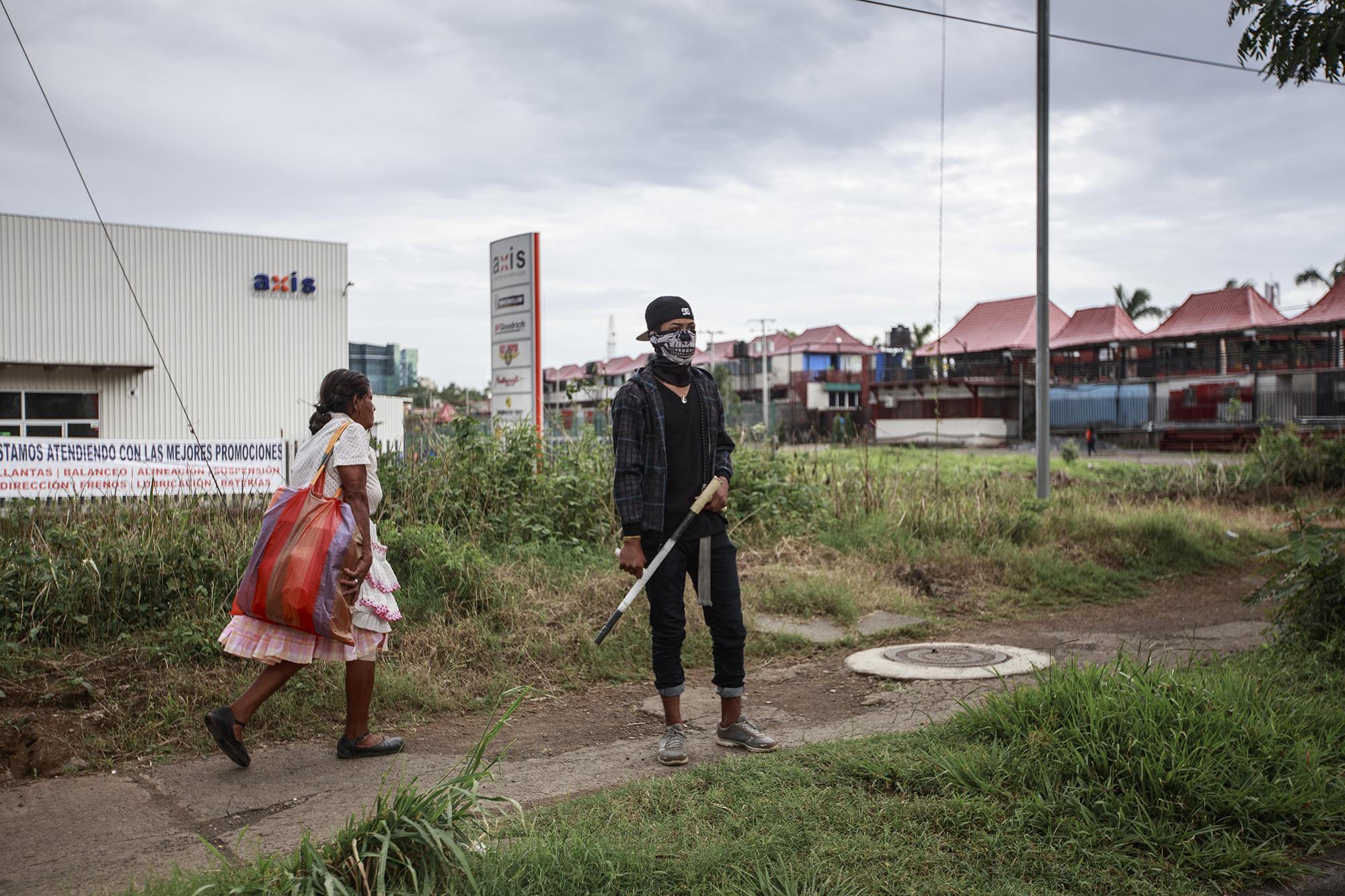 A young man with a makeshift shotgun stands guard at one of the entry points to UNAN. June 27, 2018.