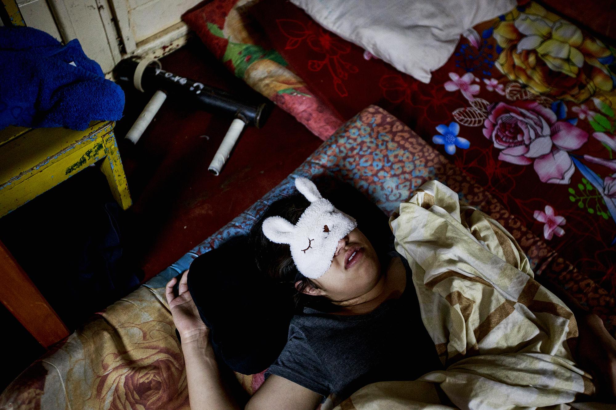 A student sleeps near her mortar in one of the childcare cabins on the UNAN campus. June 29, 2018.