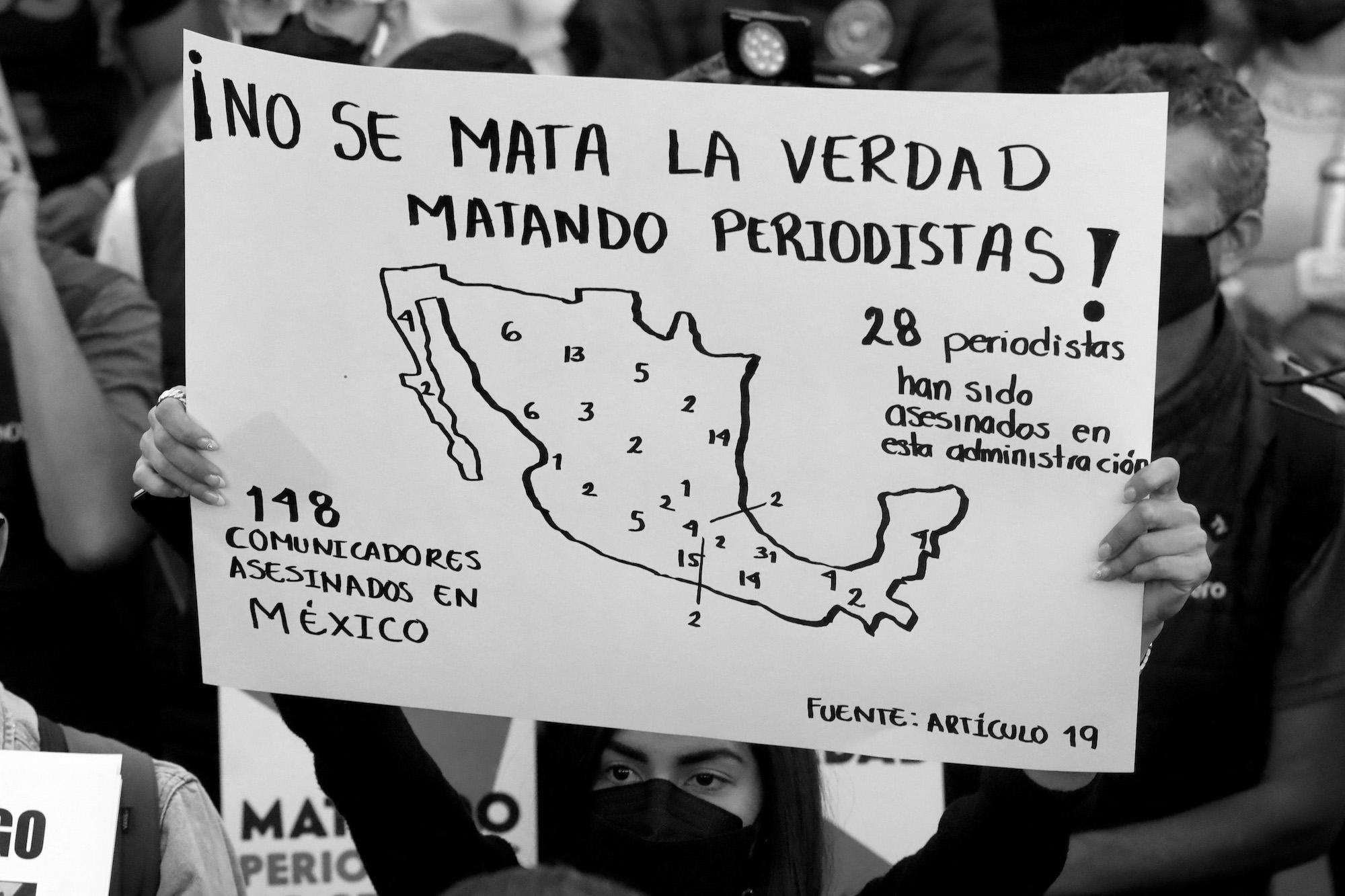 Un periodista sostiene un afiche de protesta en una  manifestación contra los asesinatos de periodistas convocada en Tijuana el pasado 25 de enero 2022. Foto: Ulises Ruiz / AFP