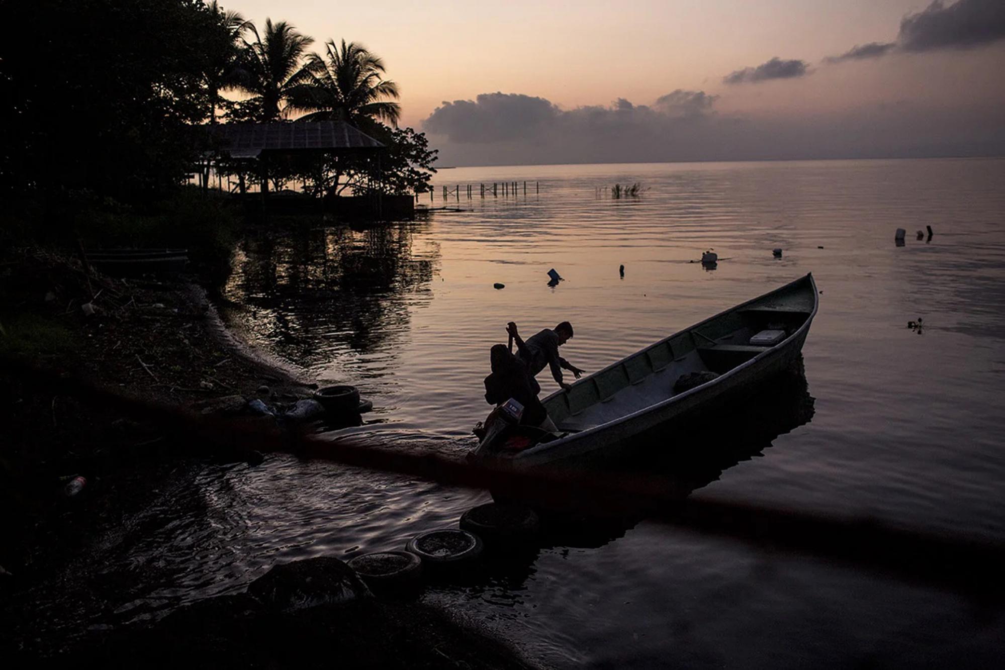 Pescadores salen a trabajar desde el lago de El Estor, en la madrugada del jueves 28 de octubre de 2021. Las comunidades indígenas han denunciado contaminación en el lago y la muerte de muchos de los animales que lo habitan, y acusan a la empresa minera. Foto cortesía: Simone Dalmasso/ Plaza Pública. 