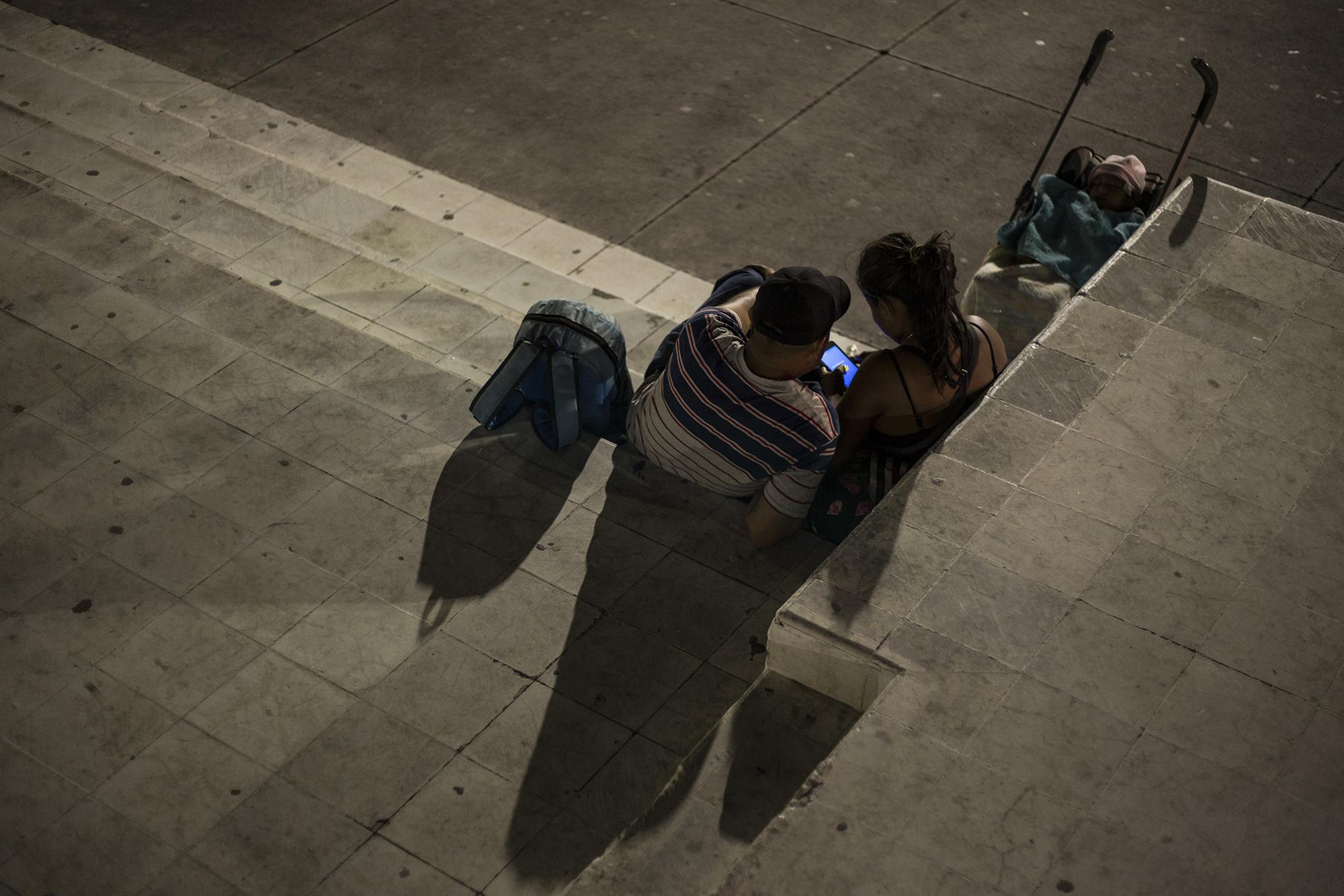 Una pareja originaria del municipio de Tonacatepeque, departamento de San Salvador, espera la salida de la nueva caravana. Al igual que Kevin, la pareja huye de amenazas de pandillas en su municipio. Foto: Víctor Peña.