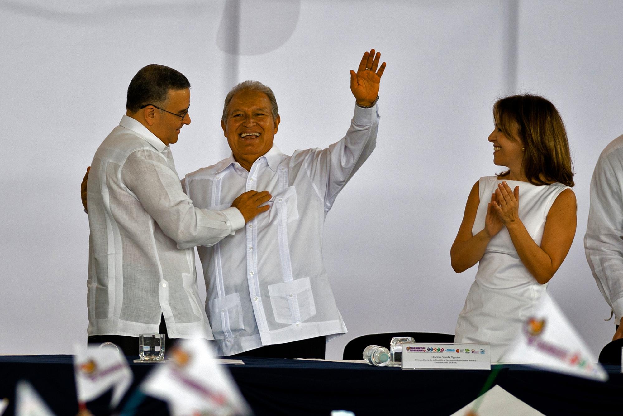 El presidente salvadoreño Mauricio Funes (izquierda) saluda al candidato presidencial salvadoreño para el Frente Farabundo Martí para la Liberación Nacional, Salvador Sánchez Cerén, durante una conmemoración temprana del Día Internacional de la Mujer en San Salvador, El Salvador, el 2 de marzo de 2014, antes de la segunda ronda de las elecciones presidenciales que se celebraron el 9 de marzo de 2014. Foto de El Faro: José Cabezas, AFP.