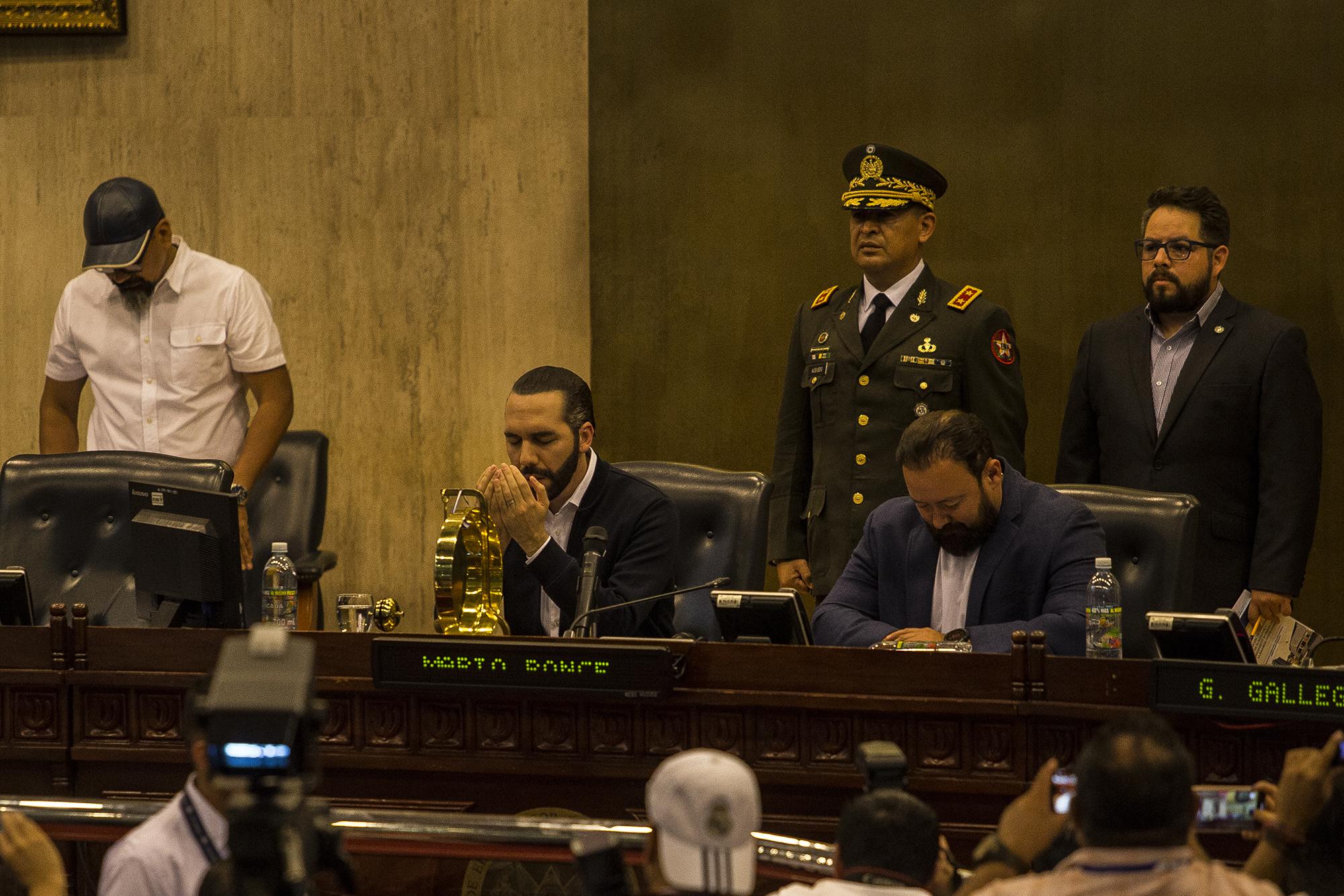 Después de amenazar a los diputados ausentes, en un Salón Azul tomado por soldados y policías, Bukele hizo una oración junto al diputado Guillermo Gallegos, de Gana. Luego, el presidente se retiró para dirigirse de nuevo a la multitud y decir que había hablado con Dios. Foto de El Faro: Víctor Peña