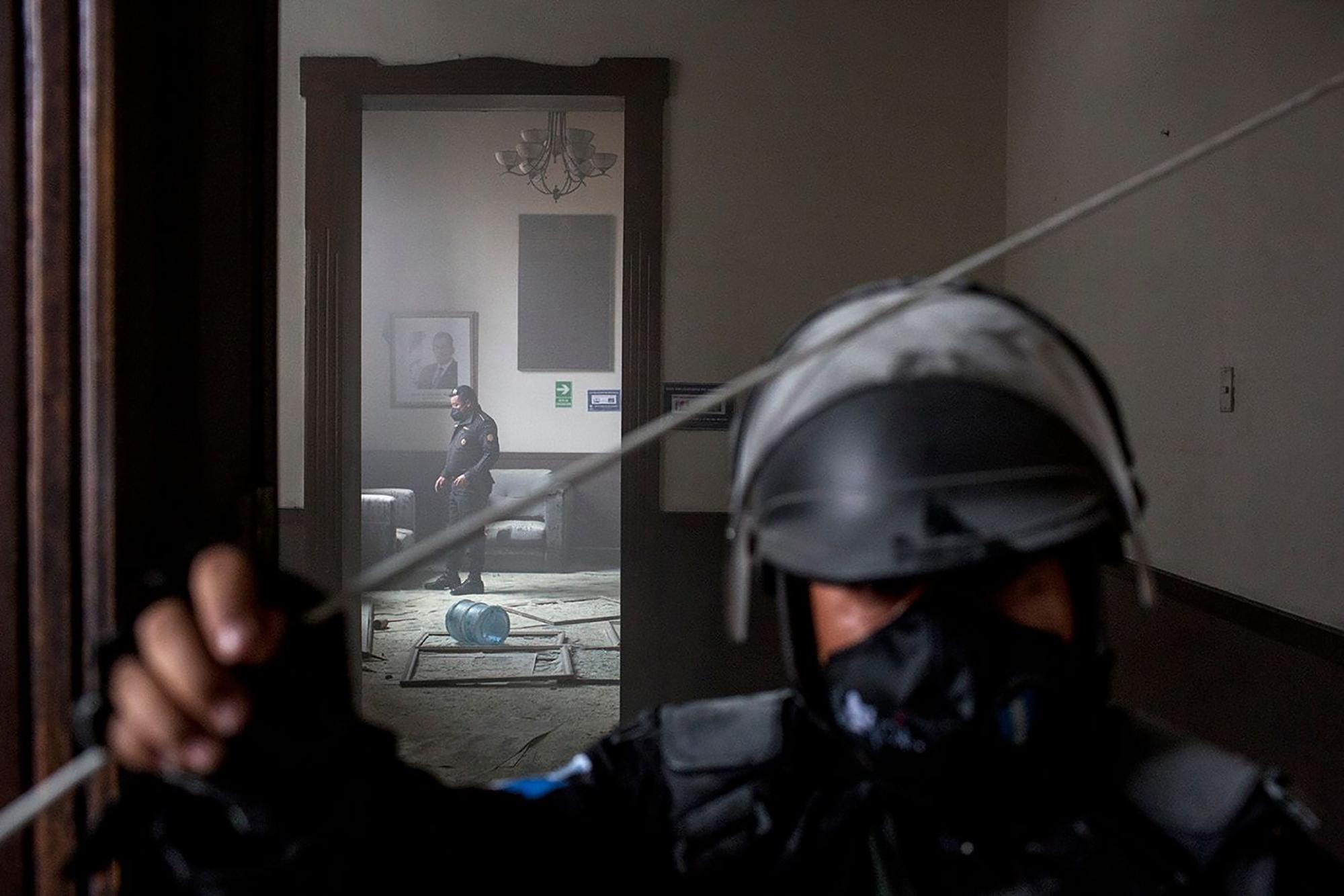 Un policía observa los escombros quemados al suelo de uno de los cuartos dañados por la quema del Congreso. Foto: Simone Dalmasso/Plaza Pública