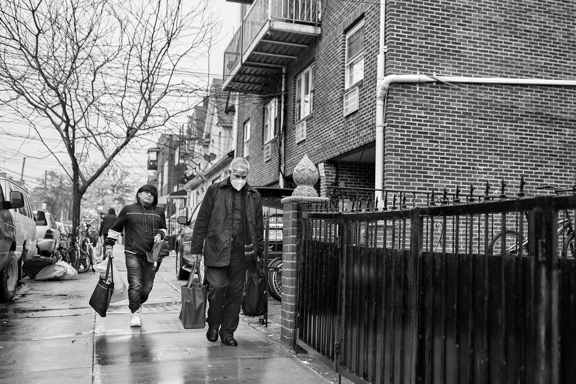 El padre Fabián y su ayudante Diego, un adolescente guatemalteco, trasladan las urnas de Nemesio y Gabriel Méndez por las calles de Corona, Queens. Este sacerdote ha oficiado un centenar de misas por la muerte de migrantes desde que inició la pandemia en 2020, todas en casas particulares de migrantes, ya que las iglesias han permanecido cerradas. Foto de El Faro: Edu Ponces/ Ruido Photo.