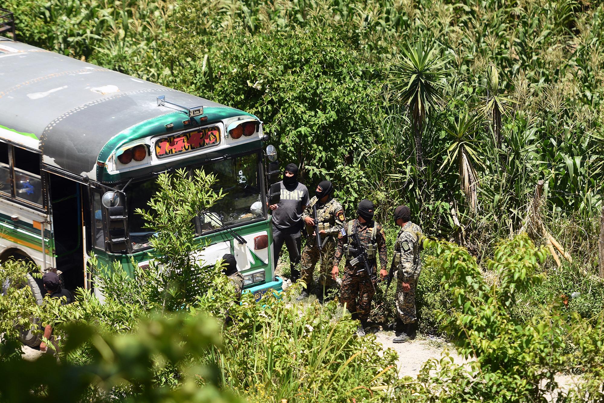 La violencia homicida batió récords en San Pedro Perulapán en 2015, con 143 asesinatos. En la imagen, tomada el 5 de agosto de aquel año, soldados custodian el bus en el que supuestos pandilleros masacraron con armas largas a cuatro personas e hirieron a otras diez en el cantón El Rodeo, en un viaje de la ruta 144-C. Foto Marvin Recinos (AFP).