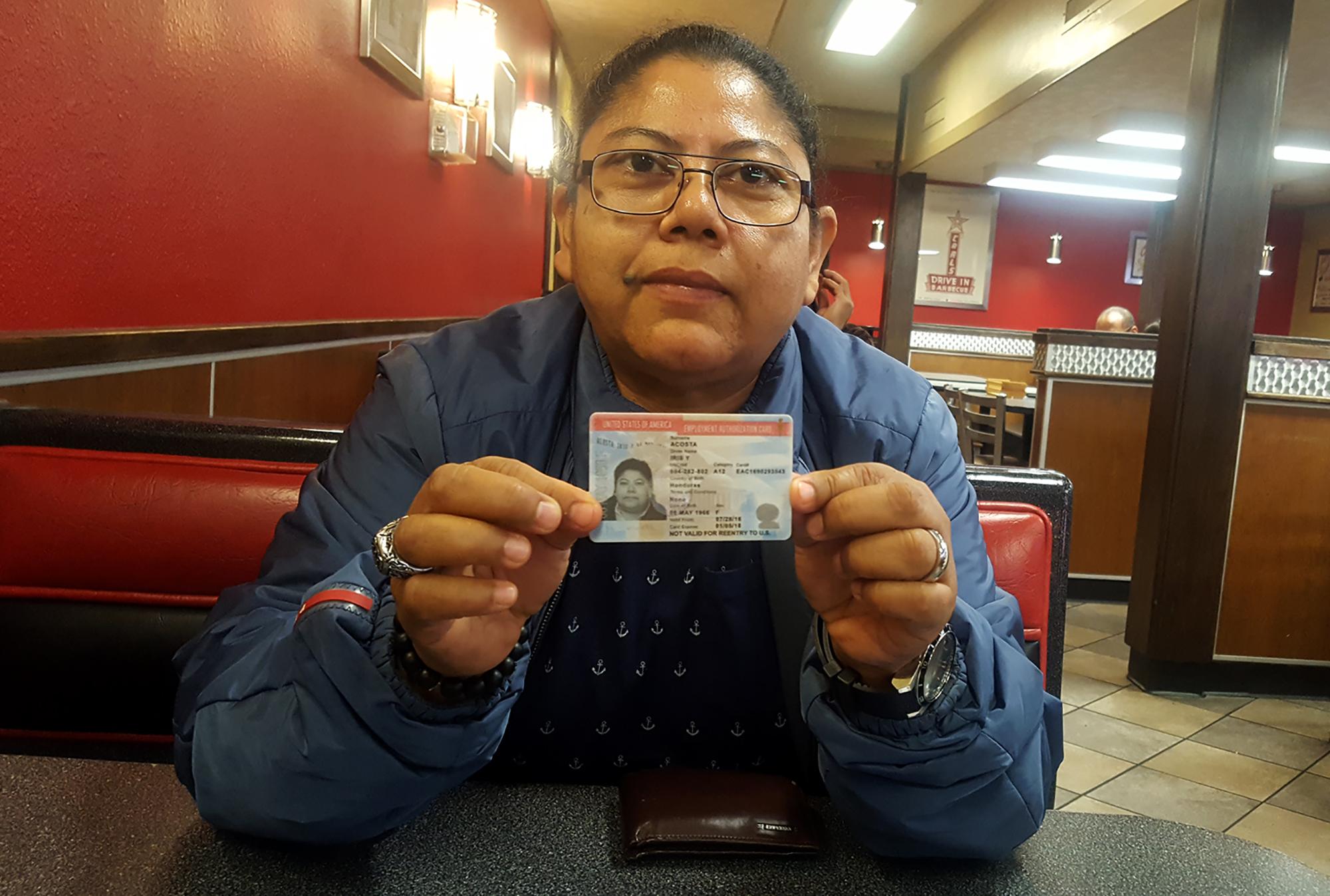 Iris Acosta, una ciudadana hondureña de 52 años, muestra el carnet que la acredita como beneficiaria del TPS´, en una cafetería de Los Angeles, California. Acosta reside en Estados Unidos desde 1992 y se arriesga a ser deportada y perder su trabajo con la cancelación del programa. Imagen tomada el 2 de noviembre de 2017. Foto de El Faro, por Nelson Rauda.