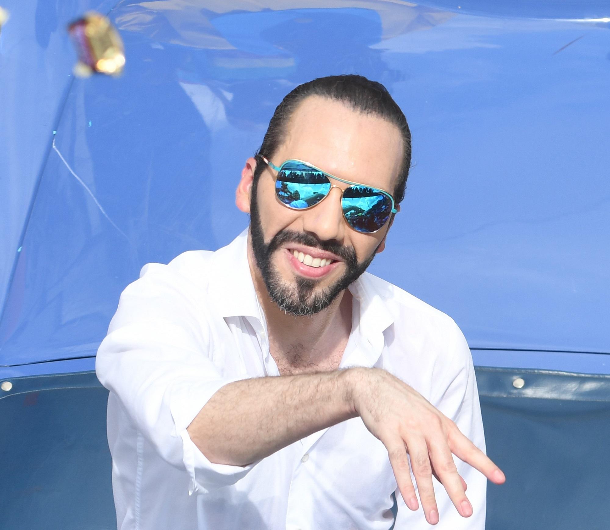 Nayib Bukele, alcalde de San Salvador, lanza chocolates Snickers durante el Desfile del Correo de la festividades del Divino Salvador del Mundo 2017. Foto Marvin Recinos (AFP).