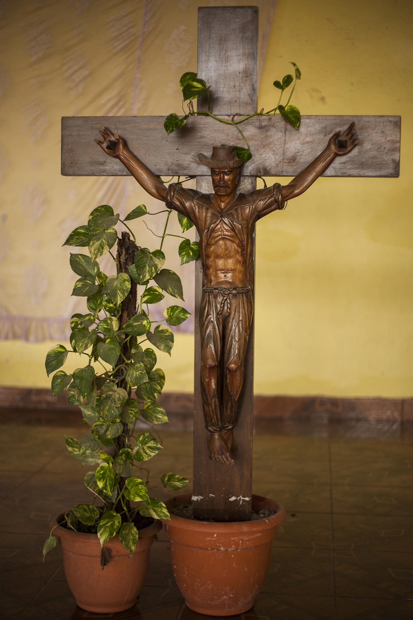 Representación de la muerte del líder campesino Felipe Huete, quien fue asesinado el 3 de mayo de 1991, durante la contrareforma agraria de Honduras, que puso en conflicto a campesinos y terratenientes. Junto a Felipe fueron asesinados Siriaco Huete, Cruz Chacón, Salomón González y Martín Huete. Los cuerpos descansan en la iglesia católica Mártires del Astillero, en la comunidad El Astillero, que antes tenía el nombre de Aguas Calientes. La comunidad está ubicada a 100 metros de la planta procesadora de Dinant, ubicada a las orillas del río Lean, en el Valle de Lean, municipio de Arizona, Atlántida, Honduras. / Foto El Faro: Víctor Peña