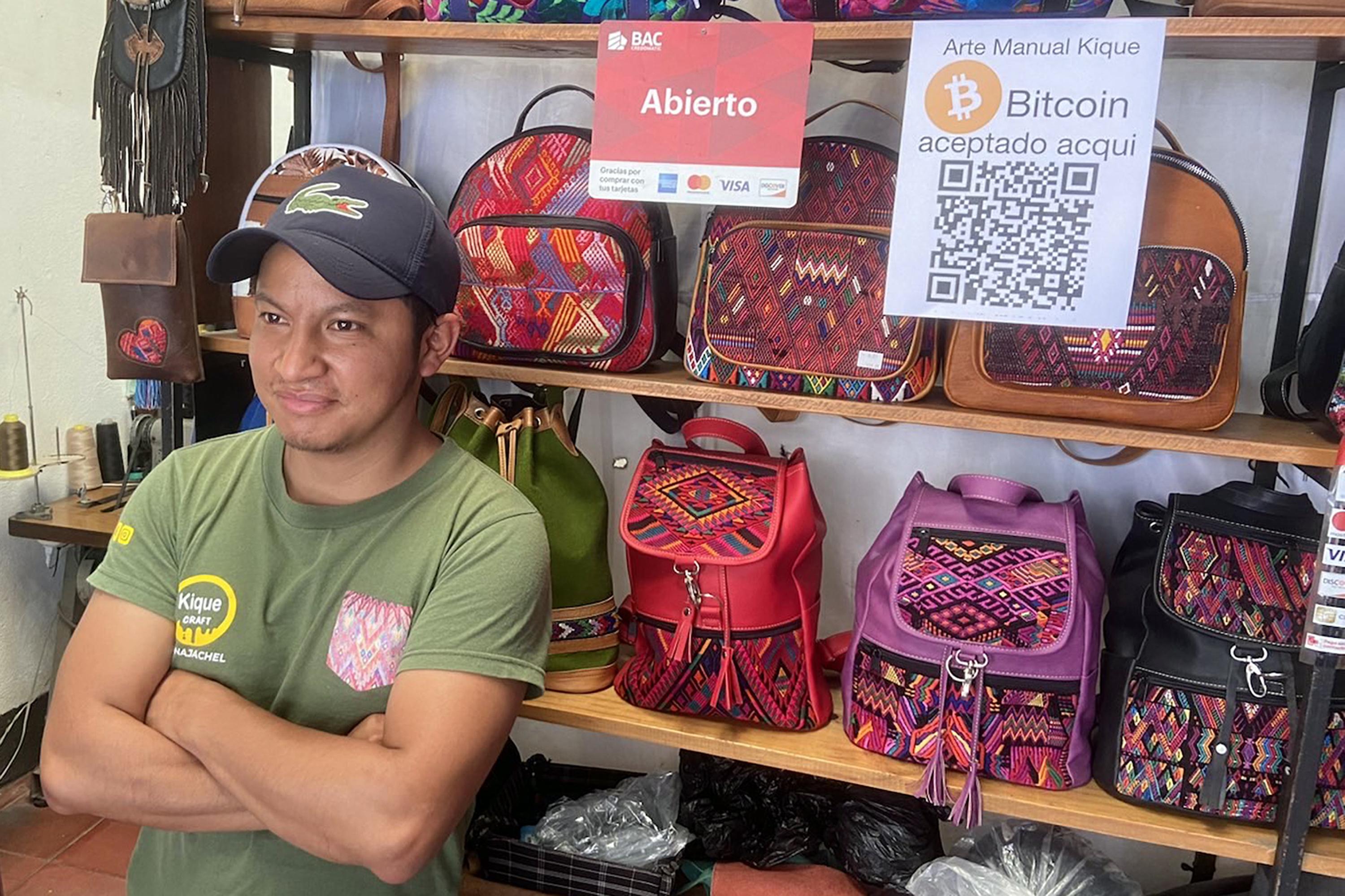 El artesano Enrique González aprovecha que haya aprendido de su padre a trabajar el cuero para vender en el mercado turístico de Panajachel. Dos años de pandemia que sofocaron el comercio local, está buscando nuevas fuentes de ingresos. El fundador de Lago Bitcoin, Patrick Melder, lo convenció a instalar un código QR en su tienda para recibir propinas pero no se atreve aún a recibir pagos. Foto de El Faro: Roman Gressier.