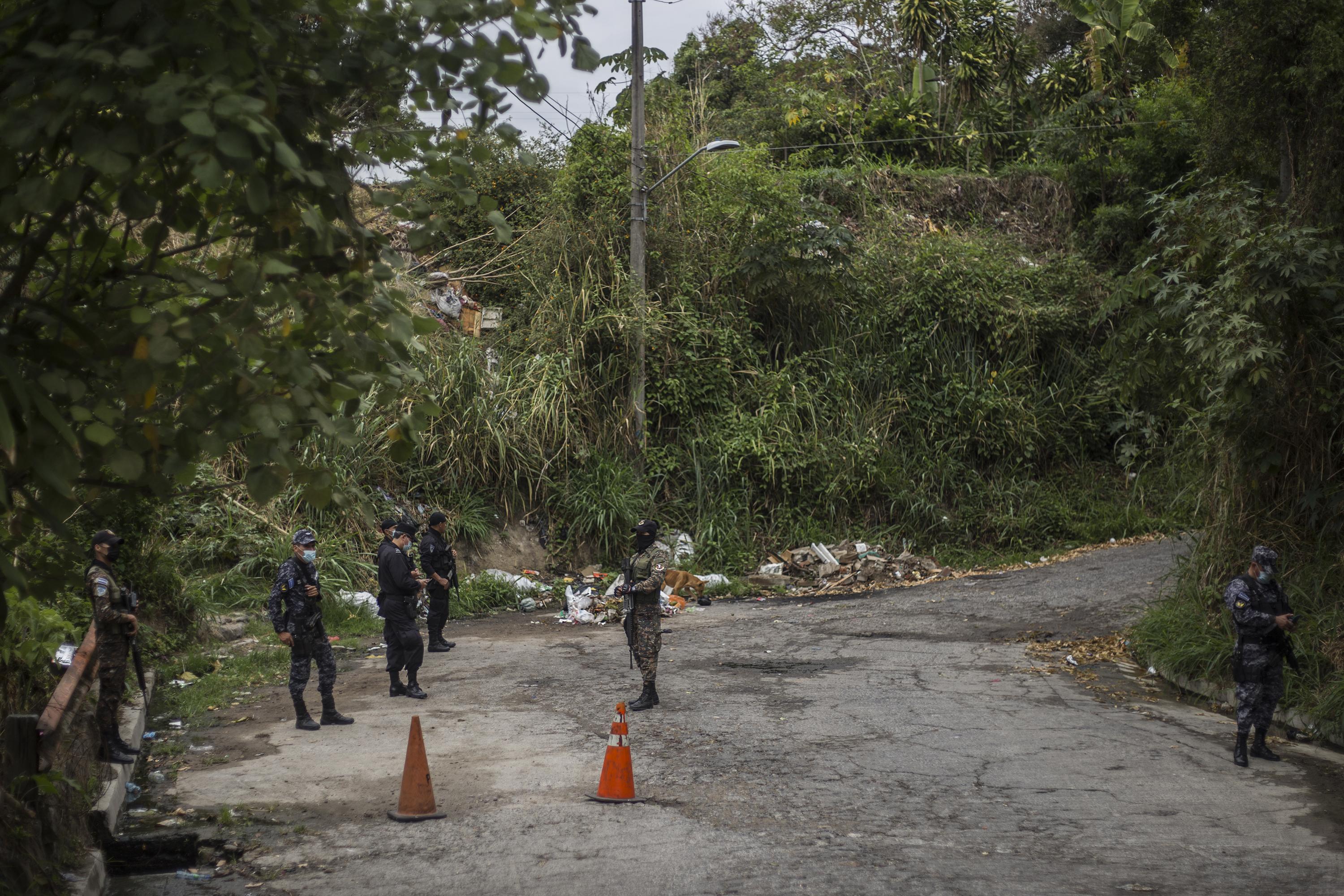 Policías y militares custodian uno de los accesos a la comunidad 22 de Abril. Las autoridades mantienen un operativo permanente desde el sábado 26 de marzo cuando el páis registró 62 asesinatos. Foto de El Faro: Víctor Peña. 