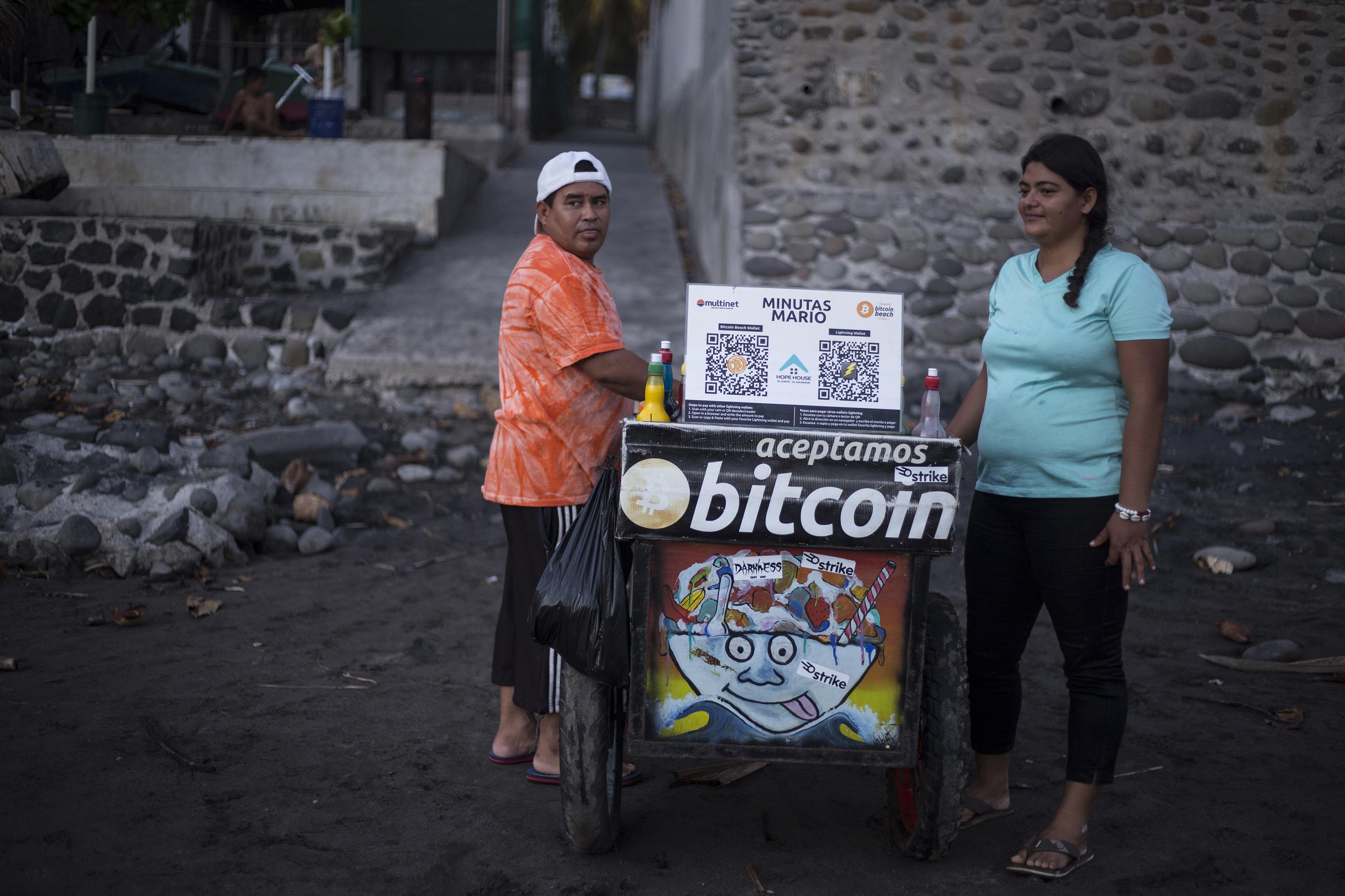 Mario de la Cruz Peña, de 46 años y Dominga de Peña, de 29, venden minutas en la playa El Zonte, en La Libertad. Esta pareja acepta Bitcoin y dinero en efectivo. Foto de El Faro: Víctor Peña.